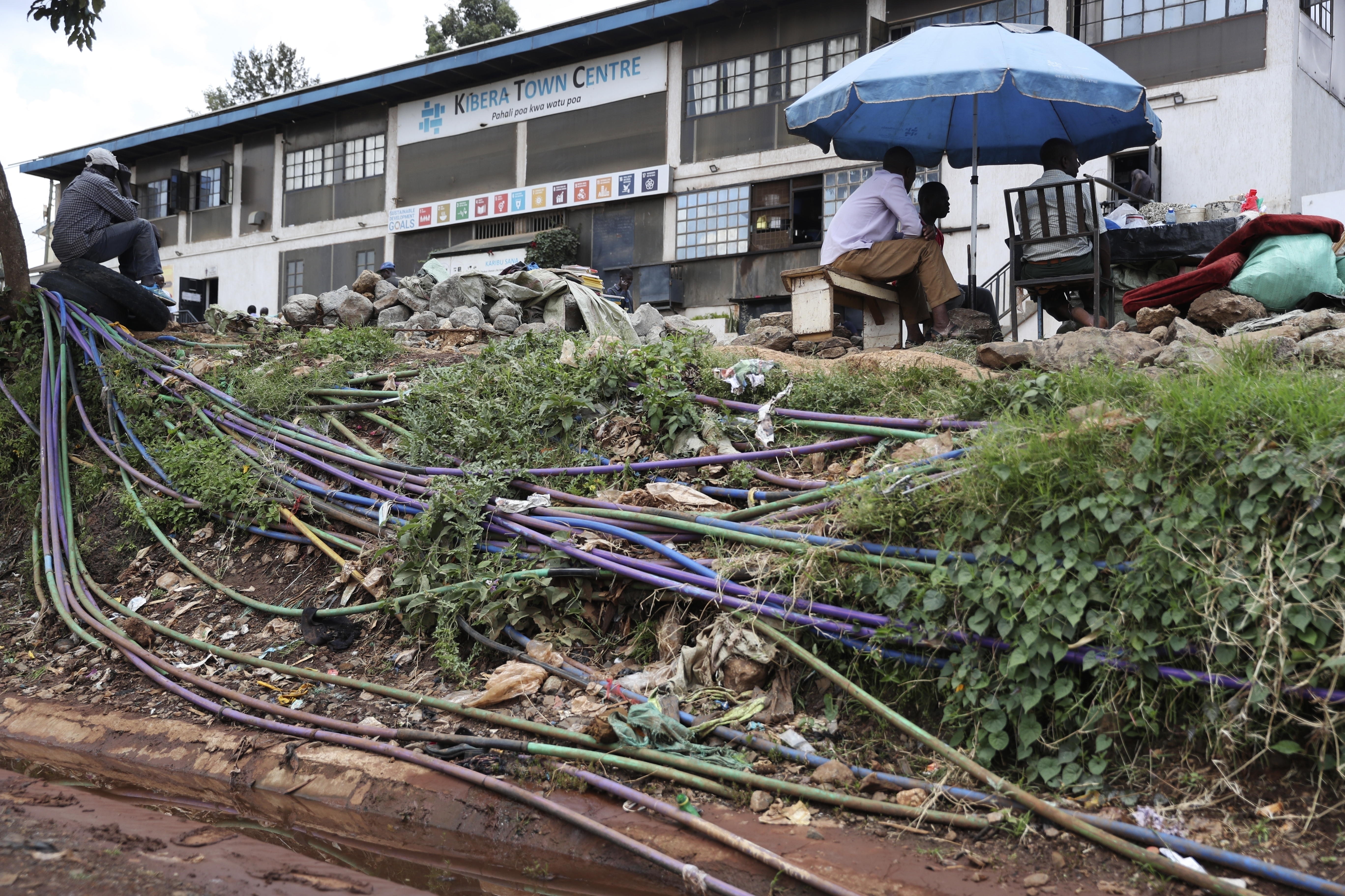 Una red de tuberías de plástico extendidas entre la tierra lleva agua a algunas de las casas de la barriada de Kibera, en Nairobi, Kenia, el 21 de marzo de 2023. (AP Foto/Brian Inganga)