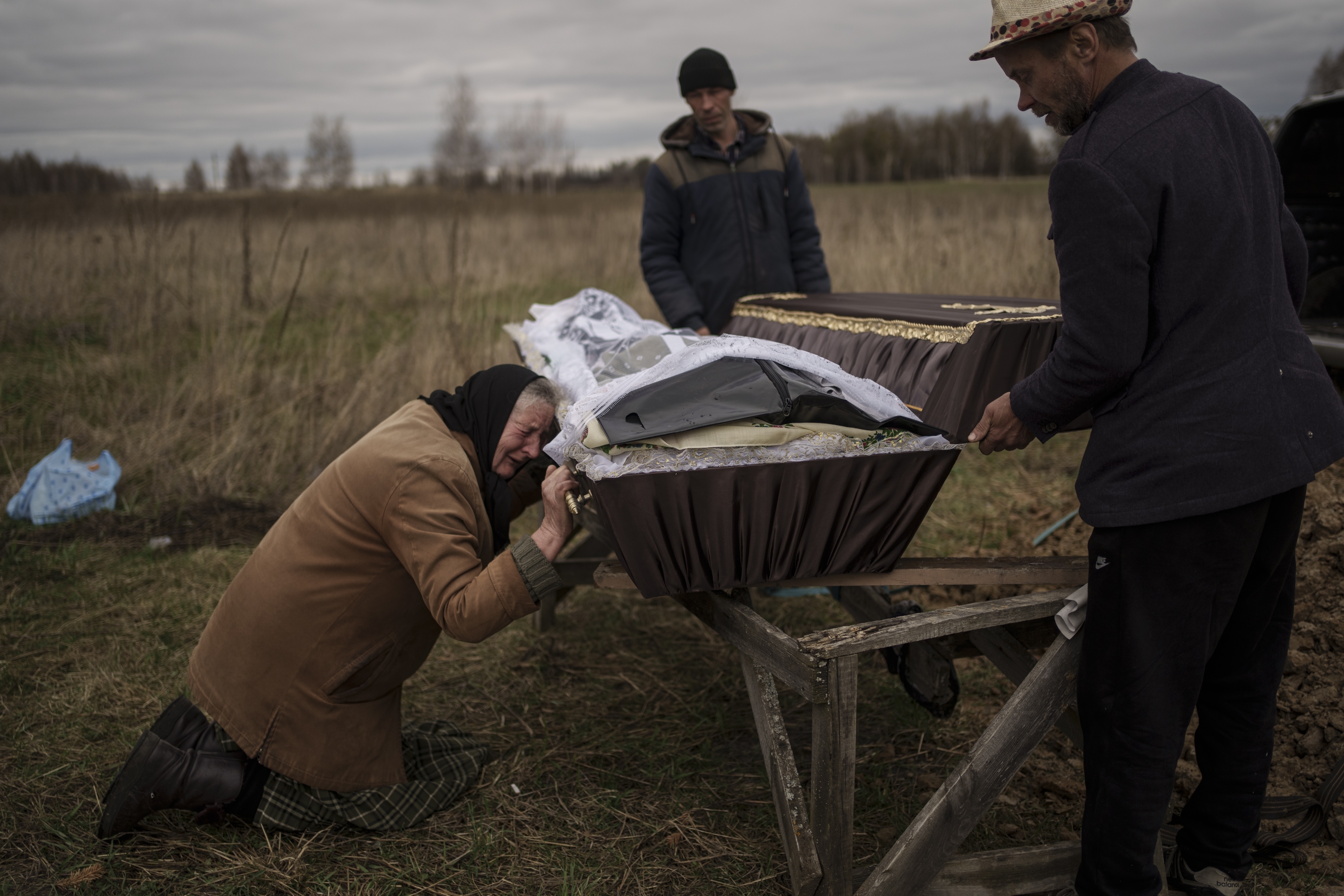 Nadiya Trubchaninova, de 70 años, llora mientras se arrodilla junto al ataúd que contiene los restos de su hijo de 48 años durante su funeral en el cementerio de Mykulychi, en las afueras de Kiev, Ucrania, el 16 de abril de 2022 (Foto AP/Rodrigo Abd)