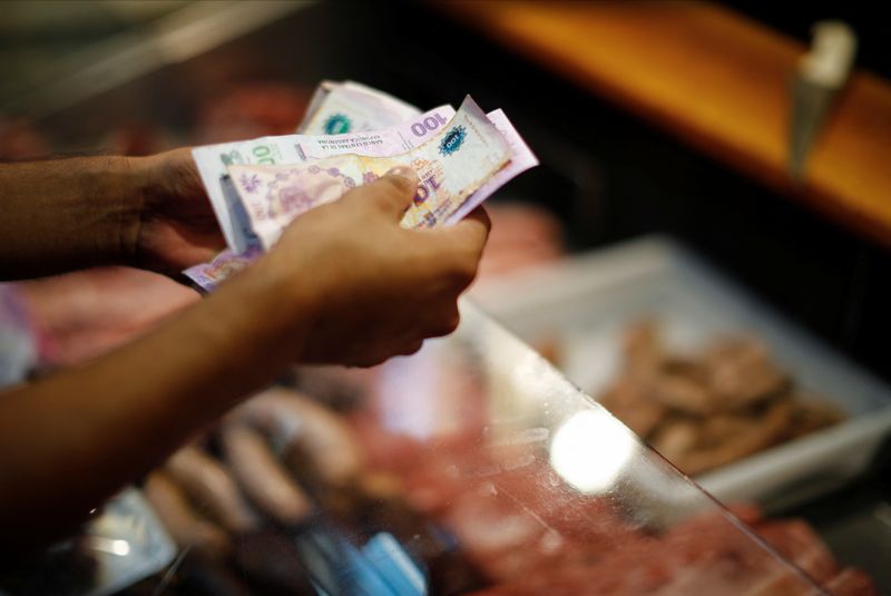 Un consumidor paga con devaluados pesos argentinos en un negocios de Buenos Aires, en medio de una Argentina que registra una inflación interanual por arriba del 100% como la más alta en casi 32 años. (REUTERS/Agustin Marcarian)
