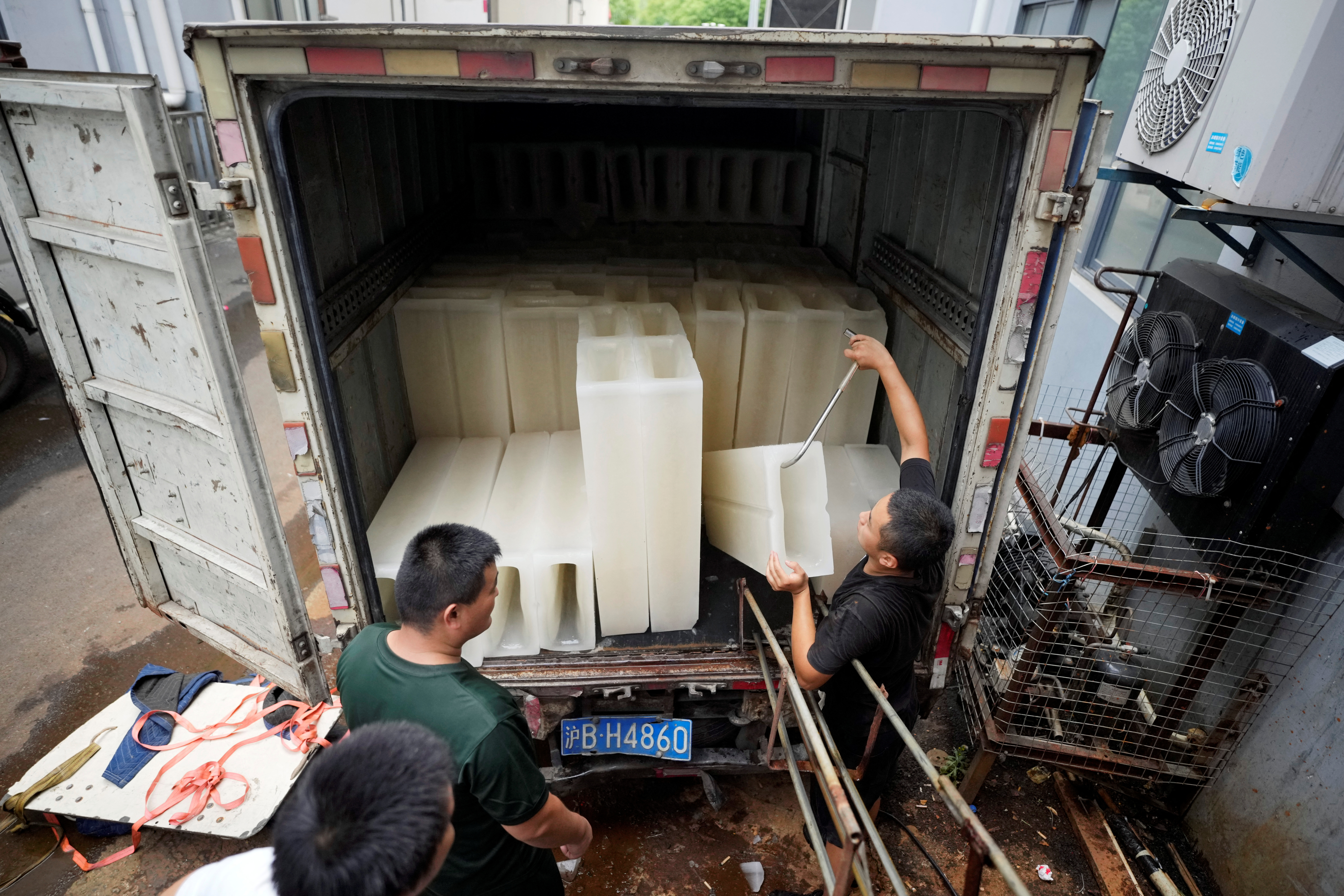Empleados trasladan bloques de hielo a un camión para enviarlos a un sitio de prueba para la enfermedad del coronavirus (REUTERS/Aly Song)
