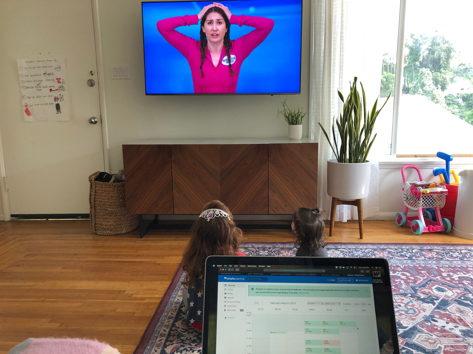 Las hijas de Saba Lurie ven un video de yoga para niños en YouTube mientras ella trabaja desde su casa en Los Ángeles. (vía Saba Lurie vía The New York Times)