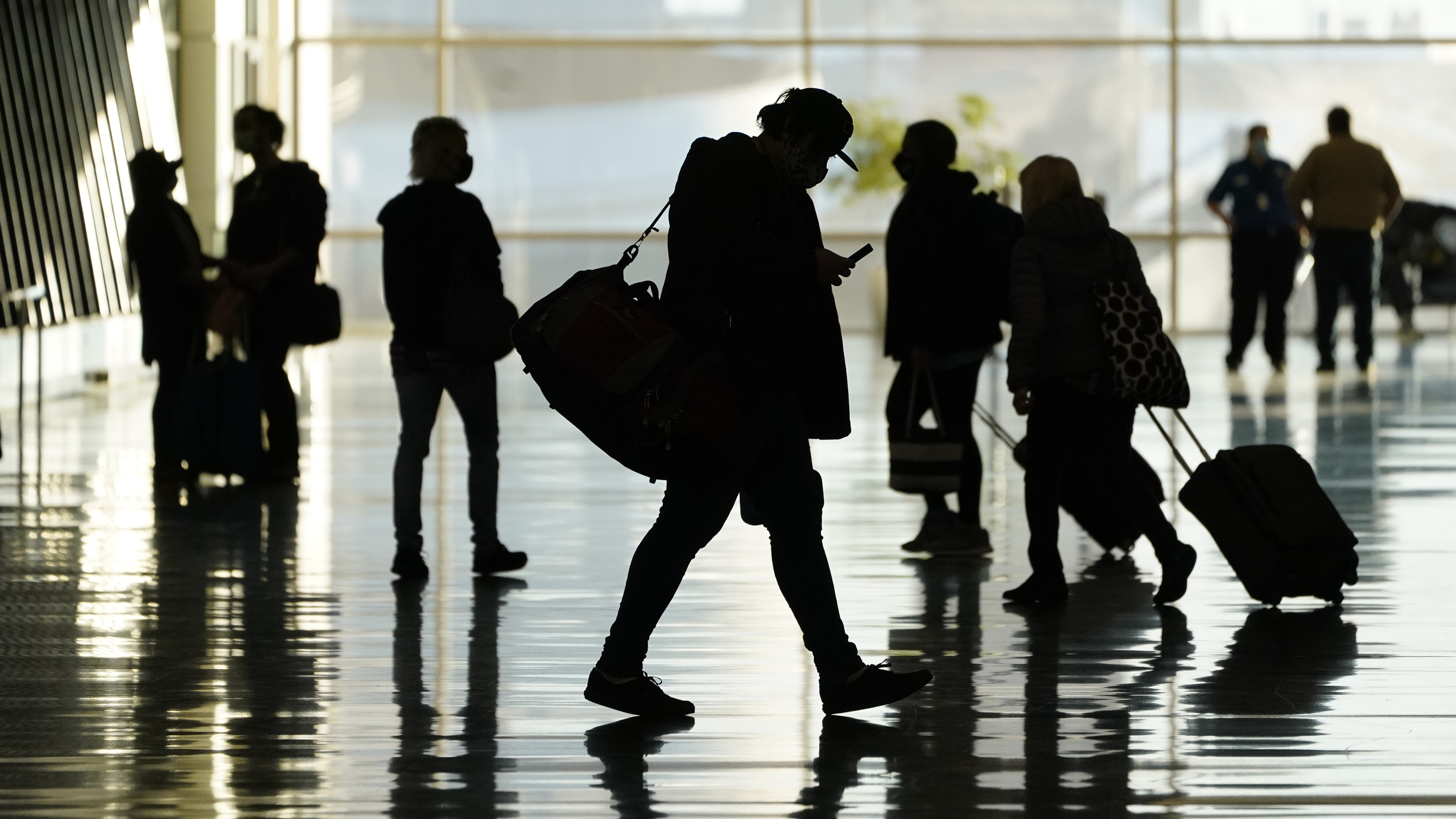 Varios pasajeros caminan el 27 de octubre de 2020 por el Aeropuerto Internacional de Salt Lake City. (AP Foto/Rick Bowmer, archivo)