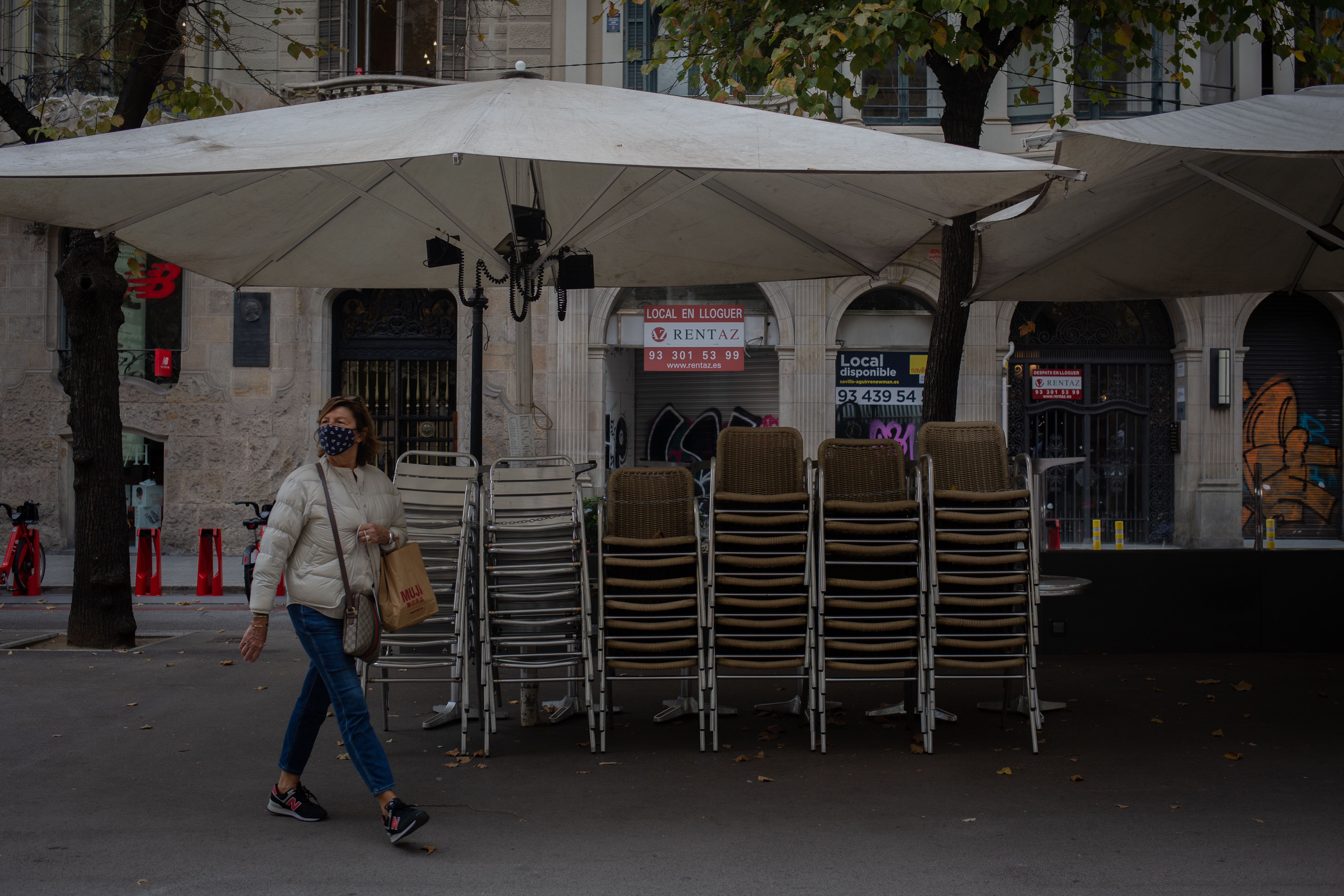 Una mujer camina por la vereda de un bar cerrado (David Zorrakino - Europa Press)
