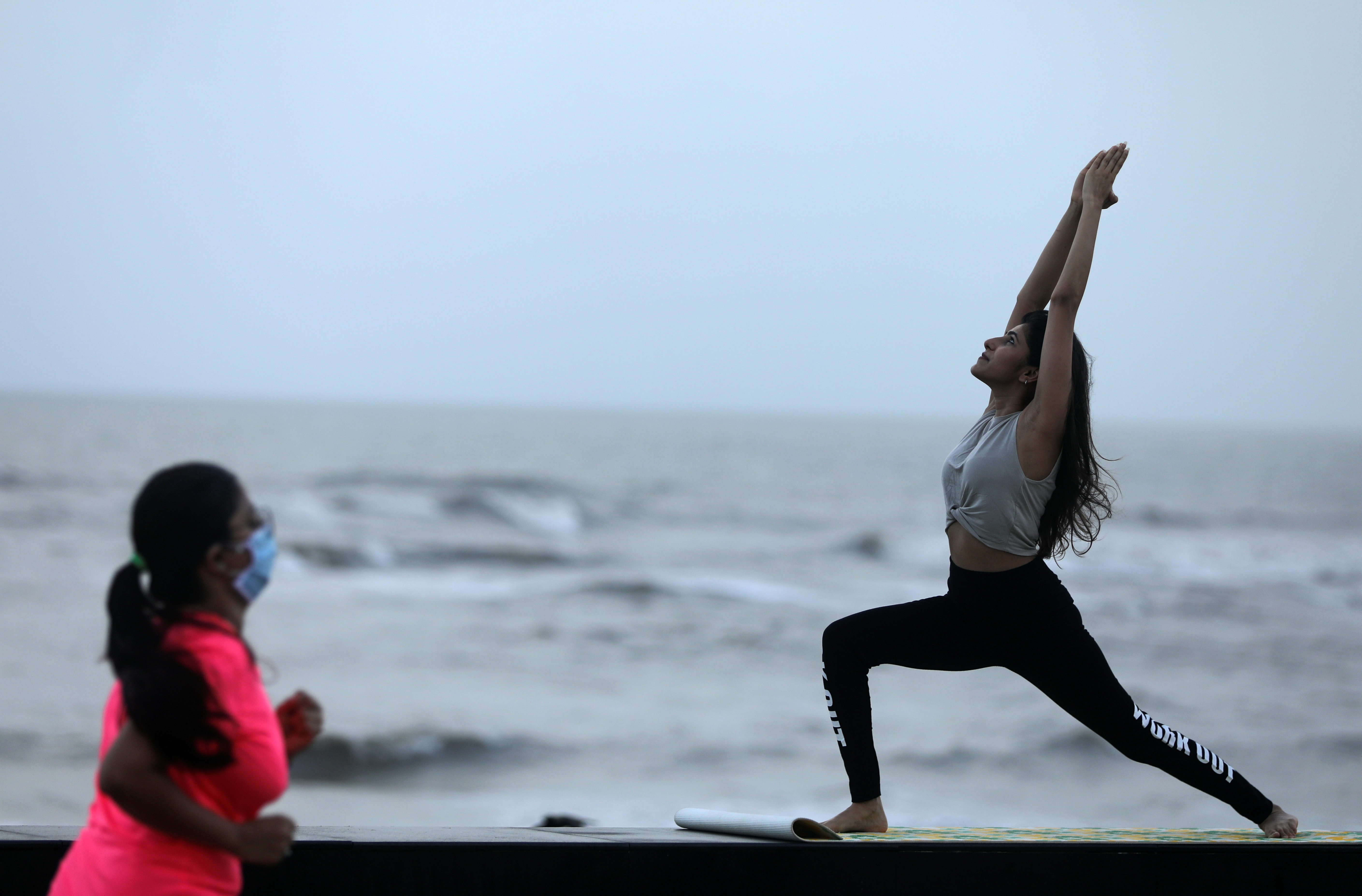 Una mujer practica yoga en la costa de Mumbai