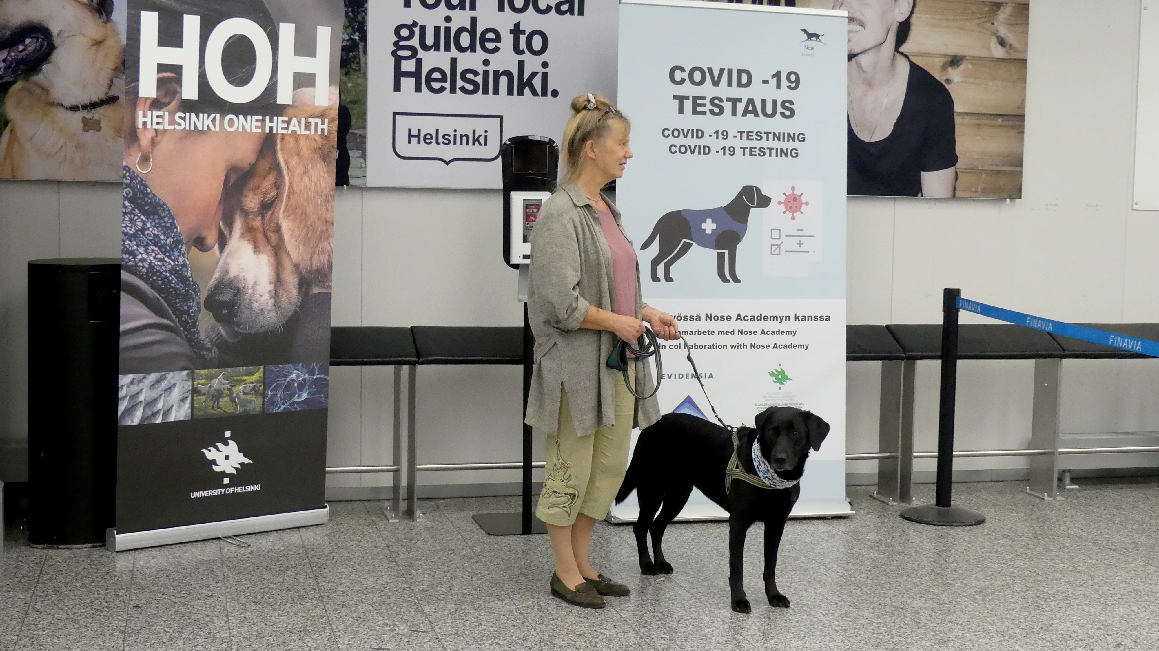 La entrenadora Susanna Paavilainen con el perro rastreador Miina, siendo entrenada para detectar el coronavirus de las muestras de los pasajeros que llegan, en el aeropuerto de Helsinki en Vantaa, Finlandia, el 22 de septiembre de 2020 (REUTERS/Attila Cser)