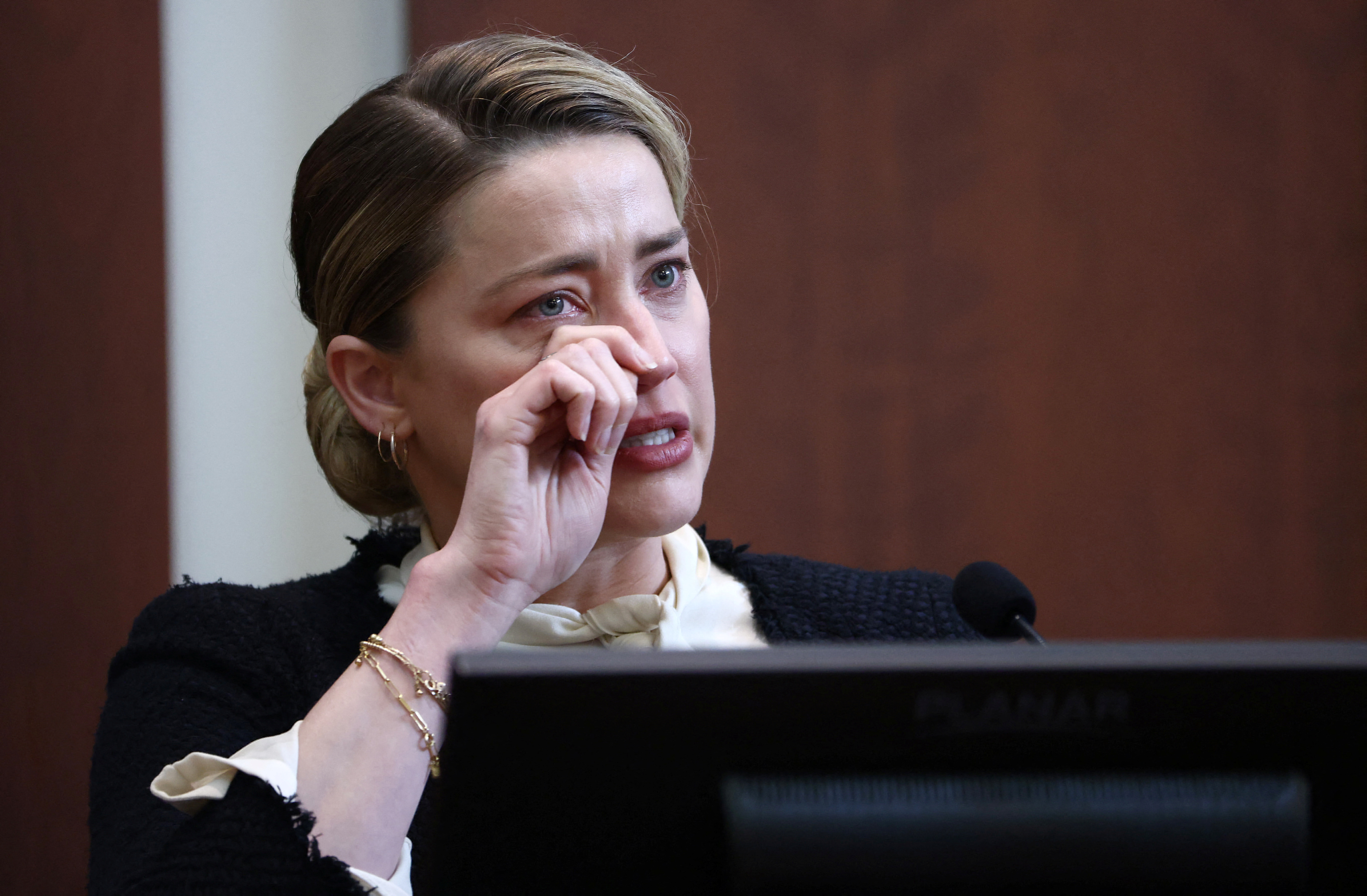 Amber Heard llora en el estrado en la sala del Tribunal de Circuito del Condado de Fairfax el 5 de mayo de 2022 (Jim Lo Scalzo/REUTERS)