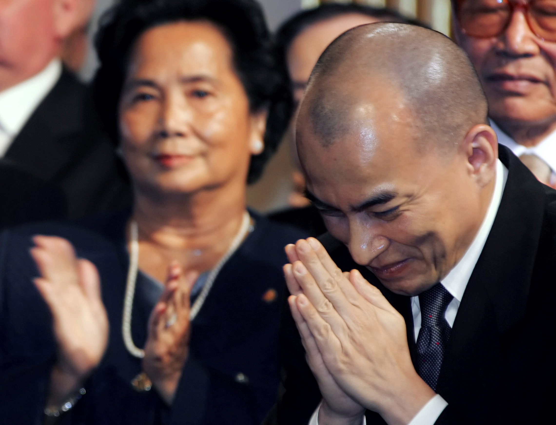 FOTO DE ARCHIVO: El rey Norodom Sihamoni de Camboya saluda durante una ceremonia mientras la princesa Bopha Devi (izquierda), hija del ex rey Norodom Sihanouk de Camboya y media hermana del actual rey, aplaude en el Ayuntamiento de París el 21 de noviembre de 2006. REUTERS/Dominique Faget /Piscina (FRANCIA)/Foto de archivo
