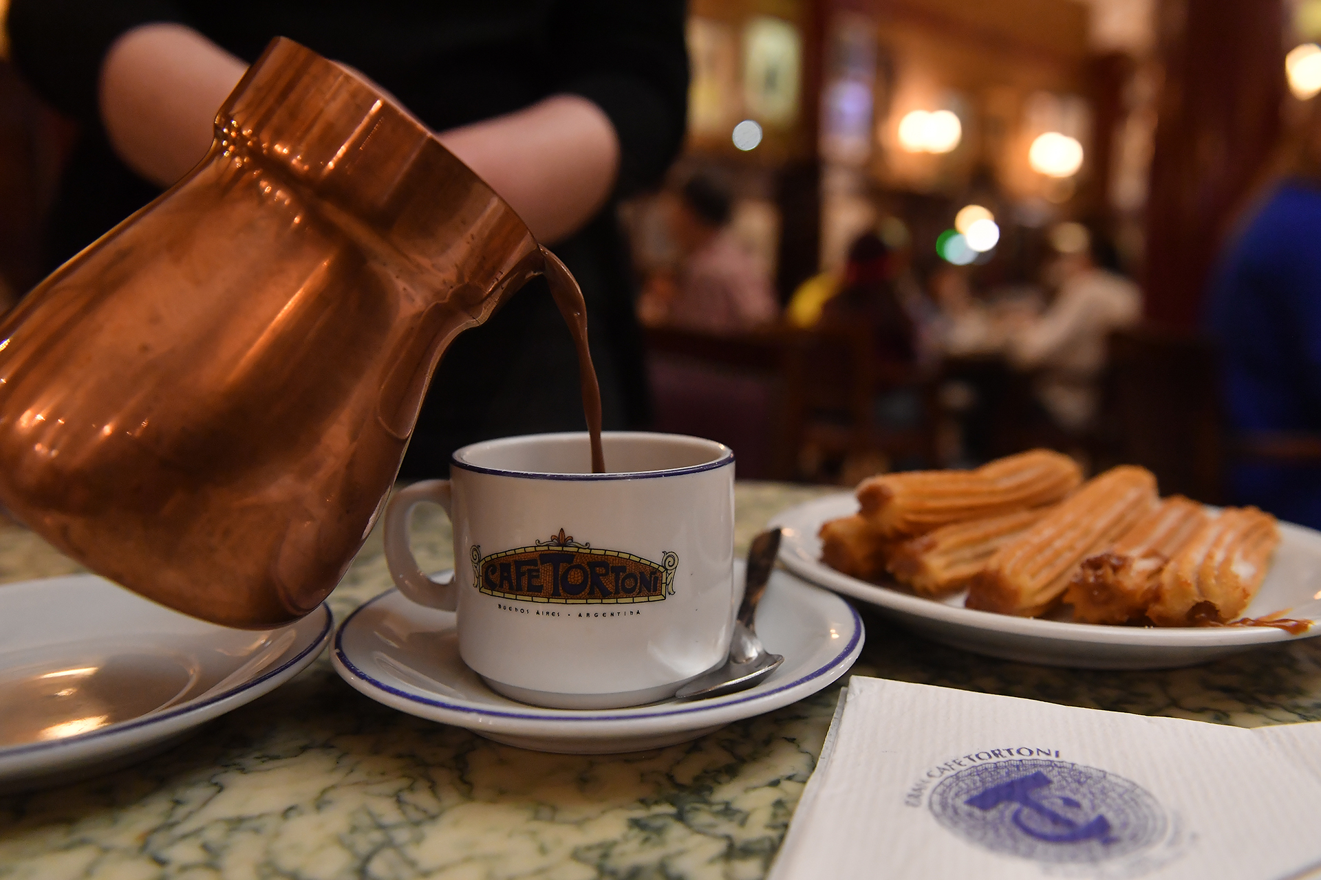 El chocolate con churros es un clásico. Llegan en una jarra de cobre, se sirve bien caliente y no hay que esperar a una fecha patria para saborearlos. (Crédito: Maximiliano Luna)