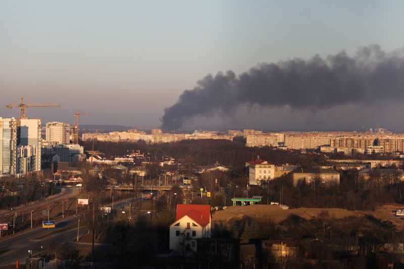 El humo se eleva por encima de los edificios cerca del aeropuerto de Leópolis, mientras continúa la invasión rusa de Ucrania, en Leópolis, Ucrania, el 18 de marzo de 2022. REUTERS/Roman Baluk