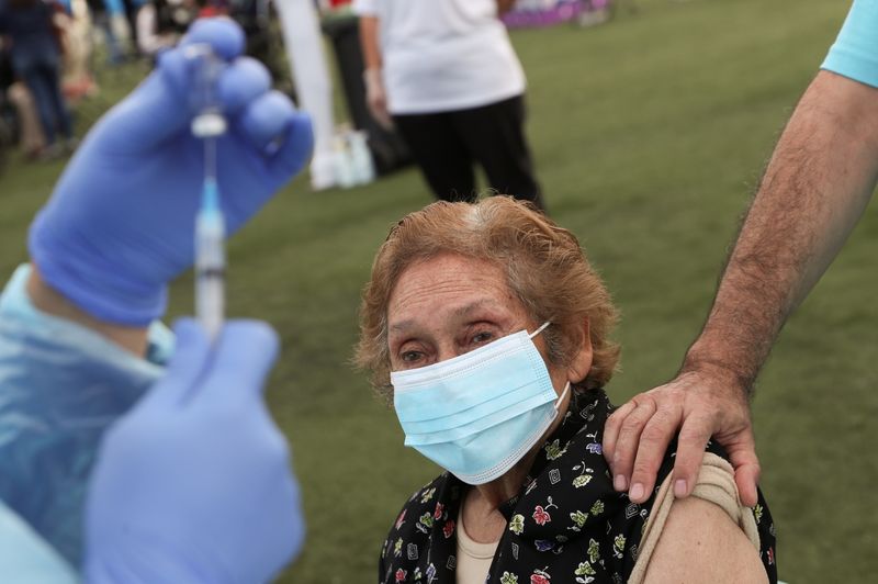 Una trabajadora de la salud se prepara para administrar una dosis de la vacuna CoronaVac de Sinovac contra el coronavirus a una mujer adulta mayor