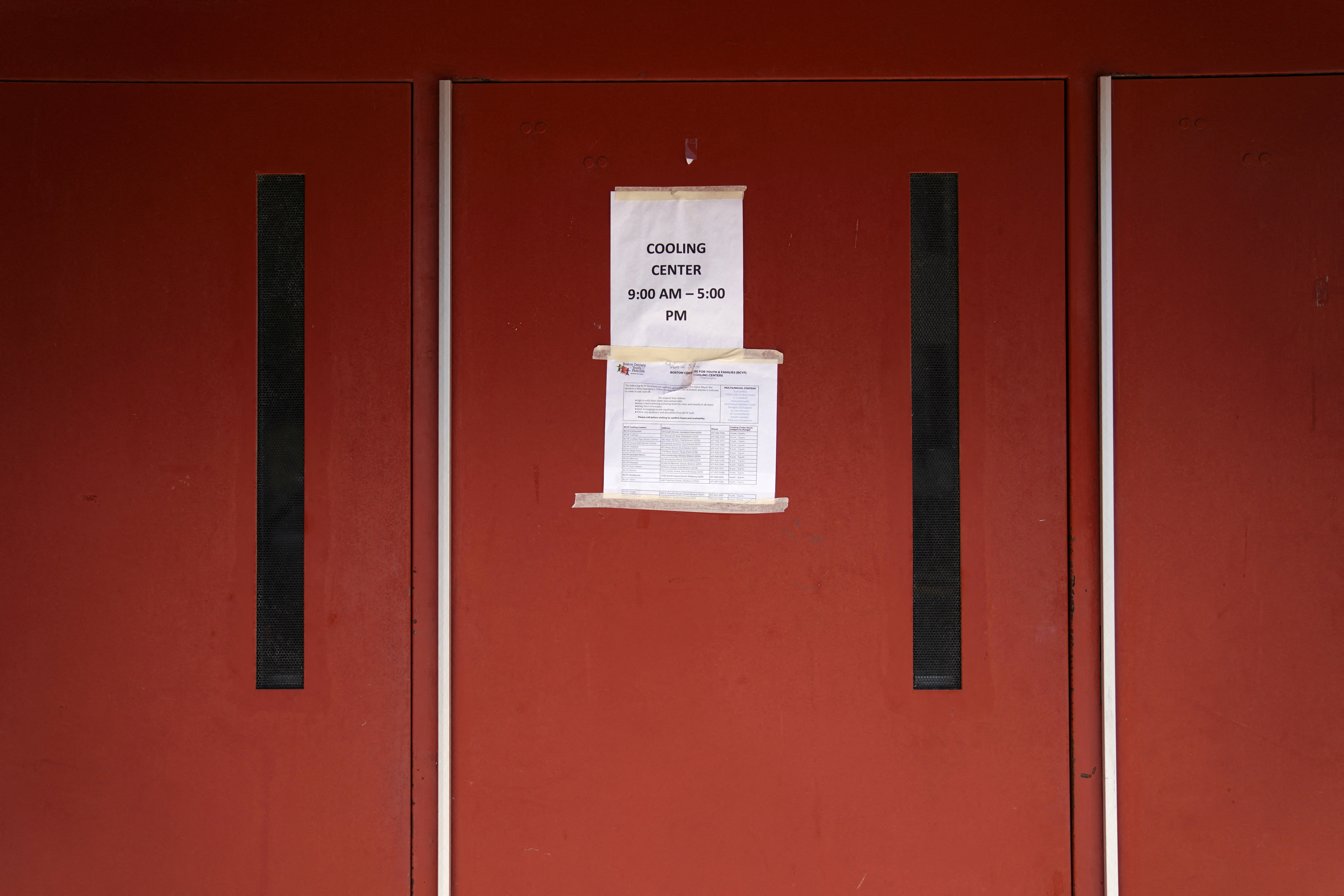 Un letrero en una puerta muestra el horario de apertura de un centro de enfriamiento durante una ola de calor en Boston (REUTERS/Allison Dinner)