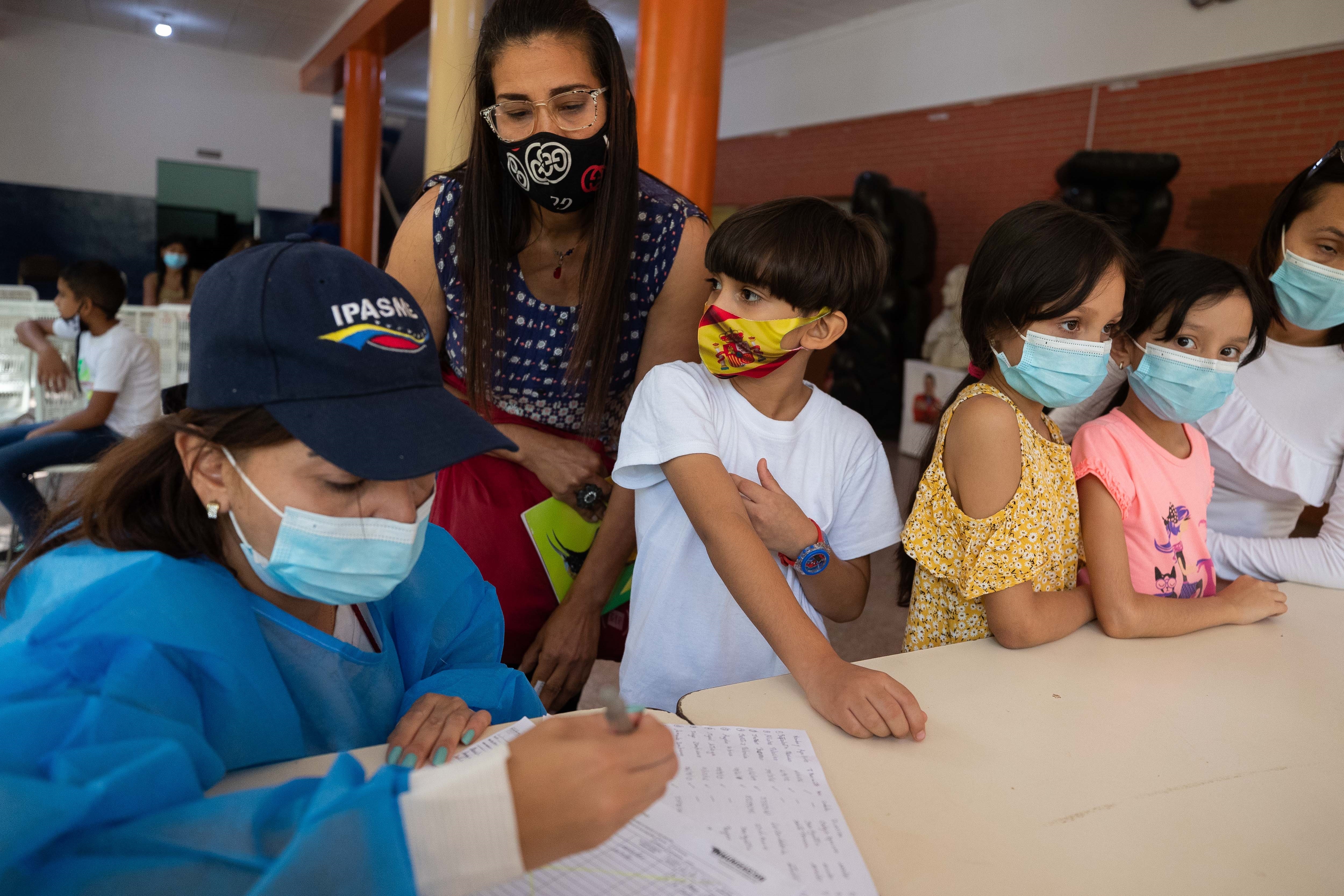 Una funcionaria del sector salud  fue captada al hacer el registro de niños vacunados contra la COVID-19, en un colegio de Caracas, Venezuela (EFE)