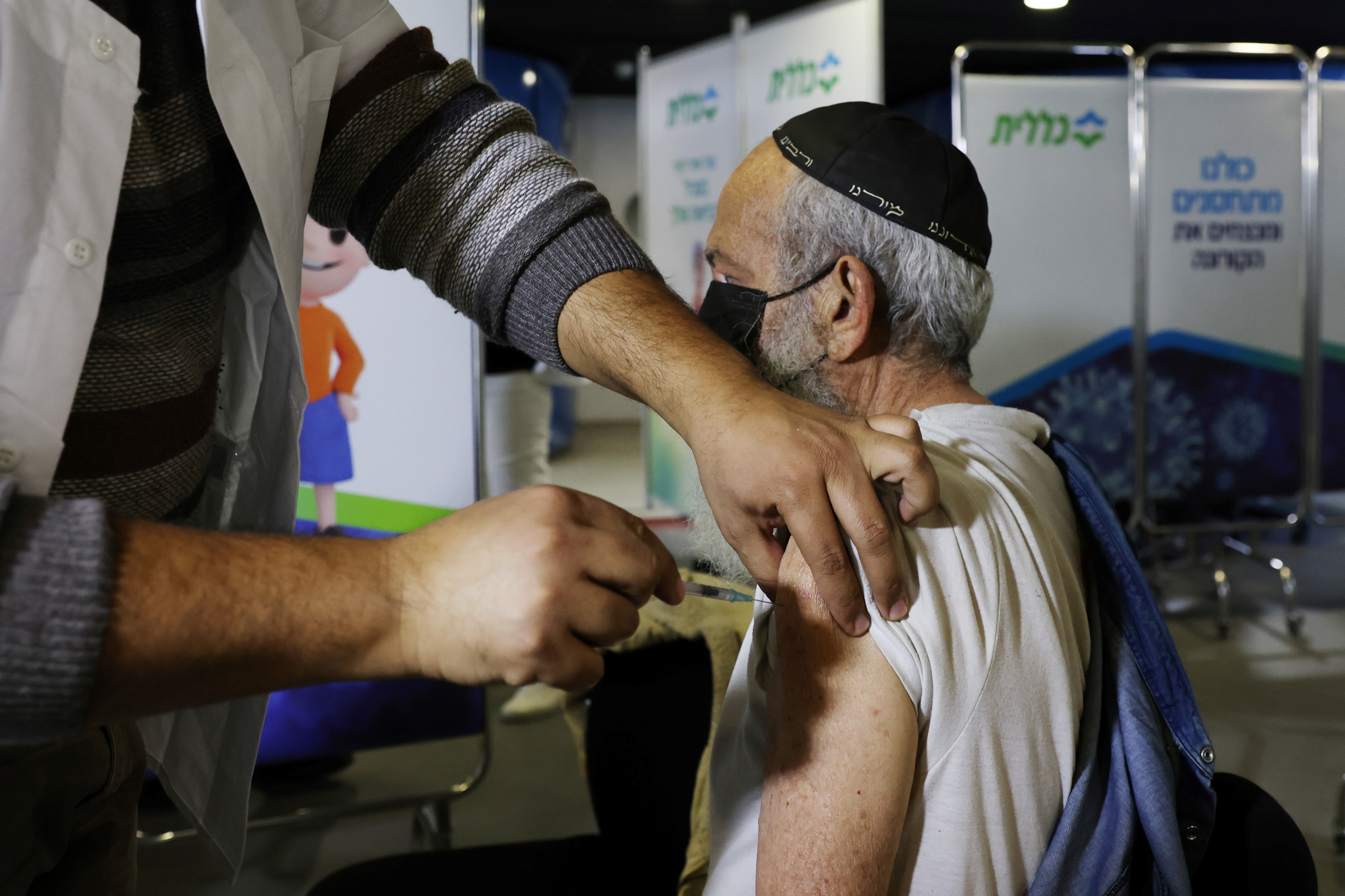 Un hombre recibe una vacuna contra la COVID-19 en un centro de vacunación en Jerusalén, el 3 de enero de 2021. Israel lidera la vacunación mundial contra el coronavirus con dosis de Pfizer (Reuters)
