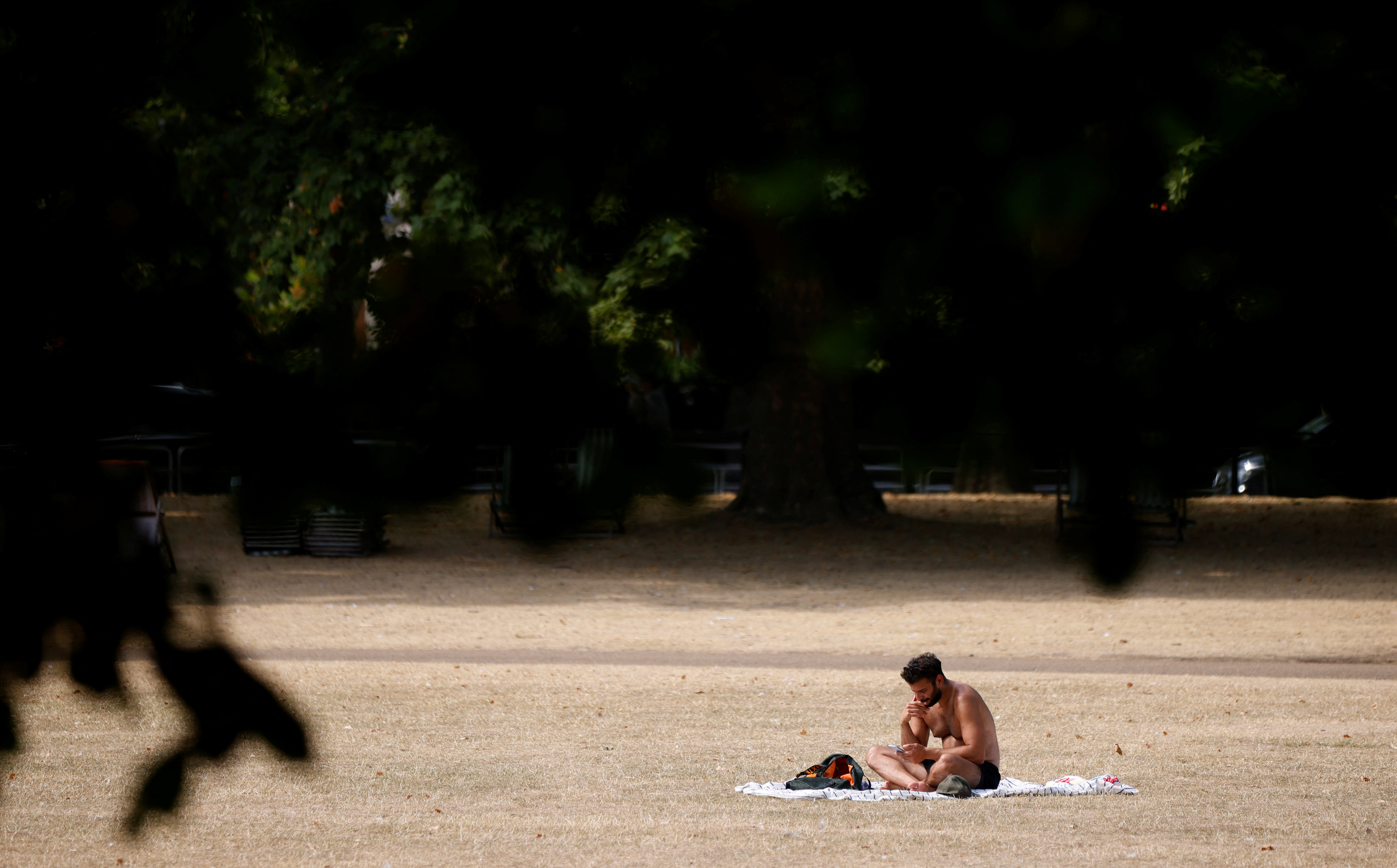 Un hombre se sienta al sol en St James's Park (REUTERS/John Sibley)