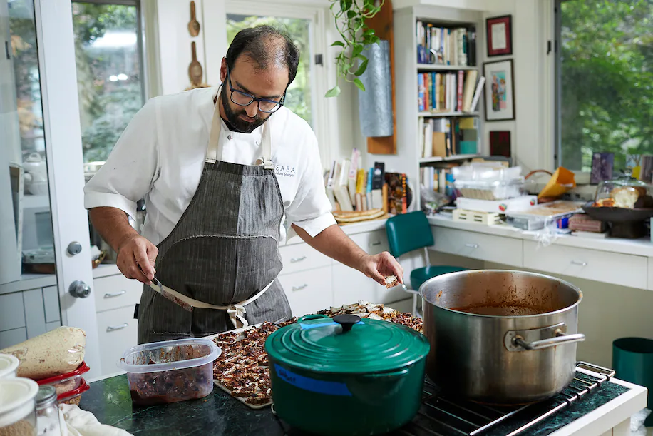 El chef Alon Shaya cocina en una recaudación de fondos para el Museo Conmemorativo del Holocausto de EE. UU. en la casa de Joan Nathan en DC en junio. (Deb Lindsey para The Washington Post)