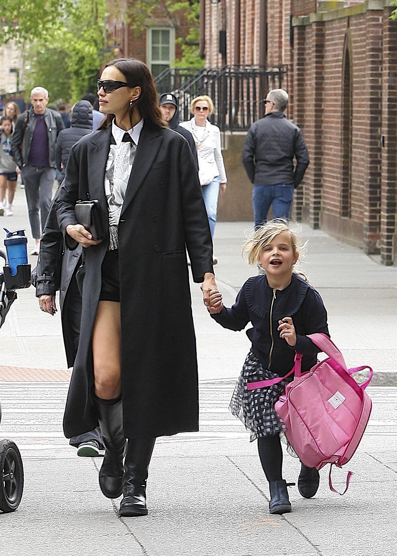 Irina Shayk fue fotografiada cuando regresaba a su casa en Nueva York luego de buscar a su hija Lea en el colegio. La modelo venía de una reunión laboral, motivo por el cual vestía un look acorde a la ocasión: camisa estampada, short negro que combinó con su tapado largo, botas de cuero y cartera chiquita. Además, llevó lentes de sol