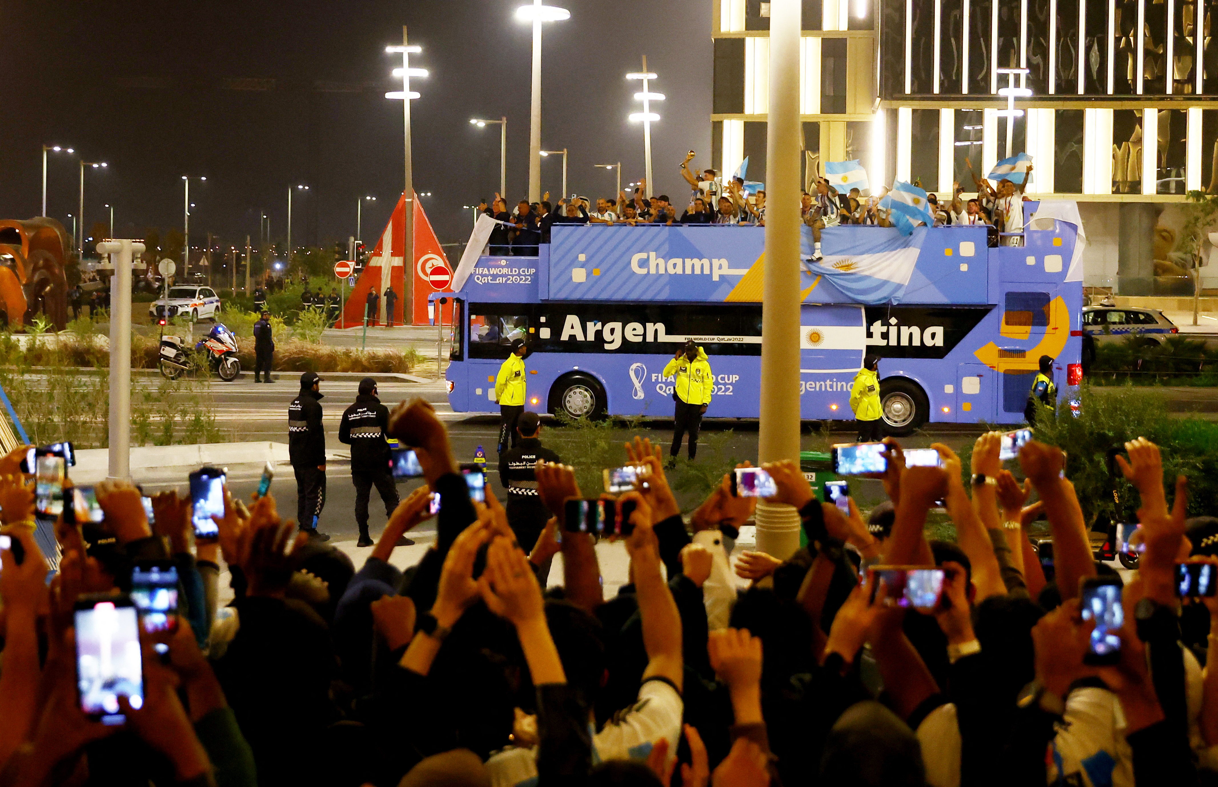 Todos los celulares enfocan el vehículo que conduce al equipo argentino a la salida del estadio donde Argentina derrotó a Francia por penales y ganó la tercera estrella 