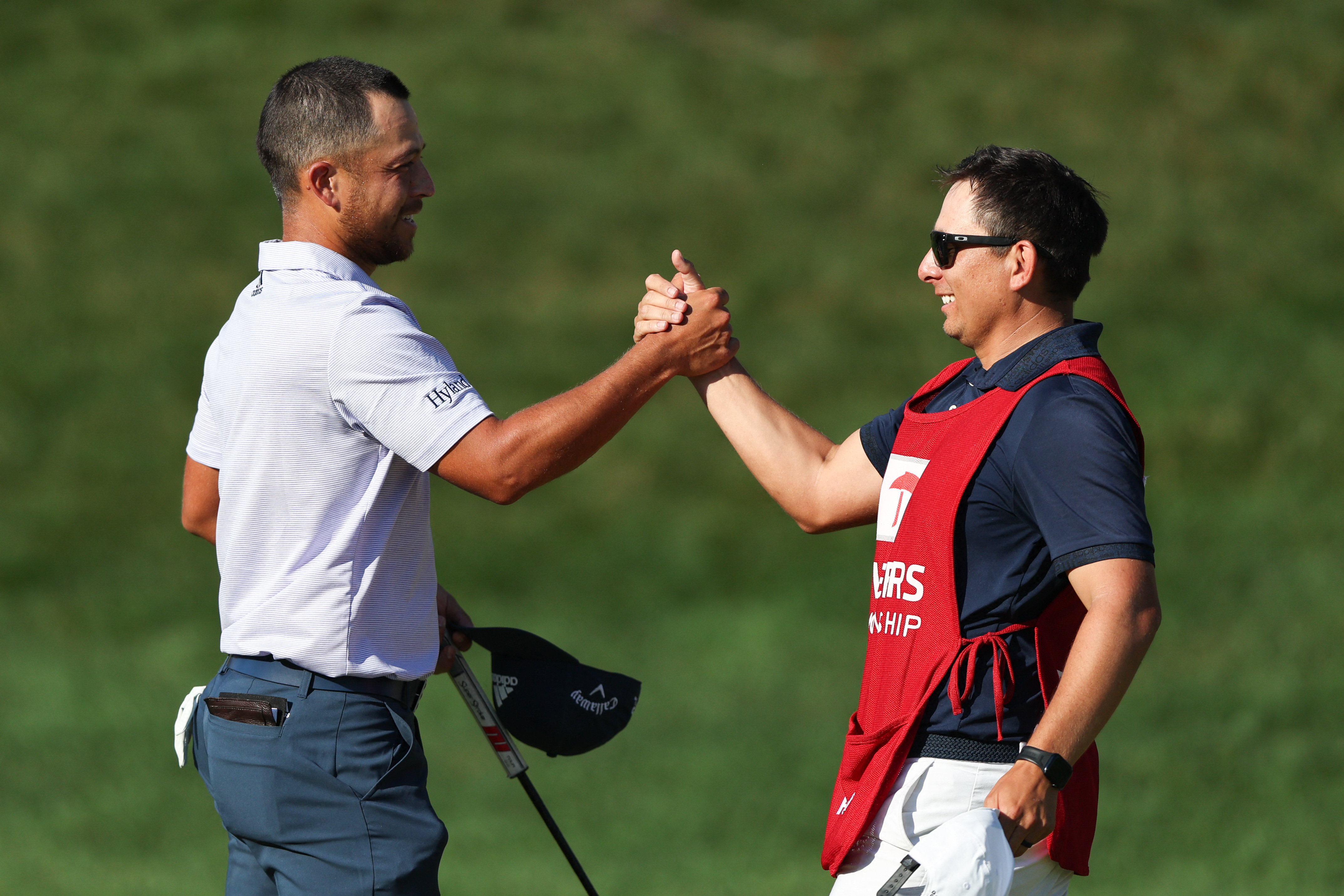 Jun 26, 2022; Cromwell, Connecticut, USA; Xander Schauffele shakes hands with his caddie, Austin Kaiser, after winning the Travelers Championship golf tournament. Mandatory Credit: Vincent Carchietta-USA TODAY Sports