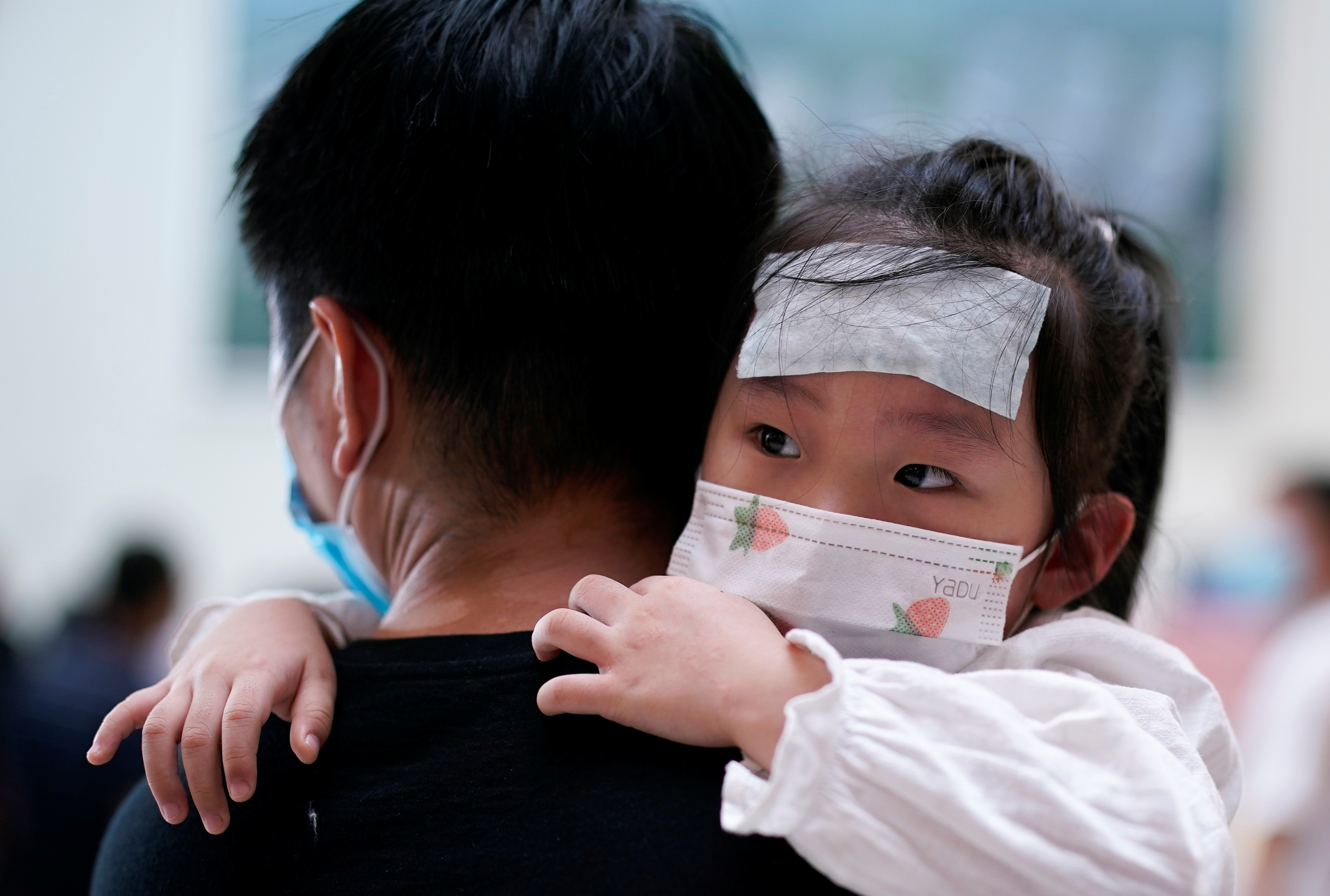 FOTO DE ARCHIVO: Un hombre lleva a una niña con una máscara facial por el Hospital Tongji en Wuhan, provincia de Hubei, China, el 3 de septiembre de 2020. REUTERS/Aly Song