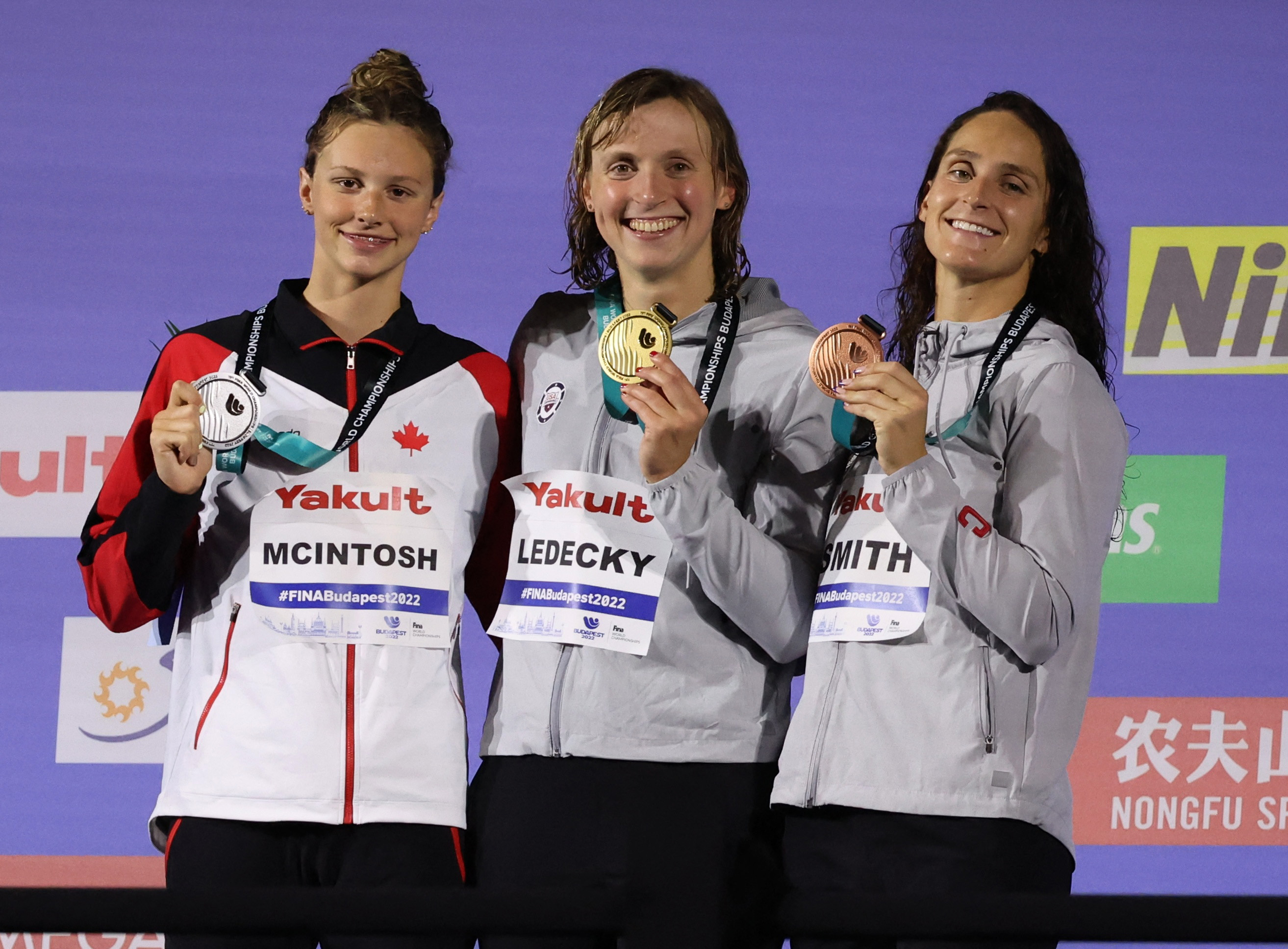 Swimming - FINA World Championships - Budapest, Hungary - June 18, 2022 Women's 400m freestyle gold medallist, Katie Ledecky of the U.S. celebrates on the podium with silver medallist, Canada's Summer McIntosh and bronze medallist, Leah Smith of the U.S. REUTERS/Antonio Bronic
