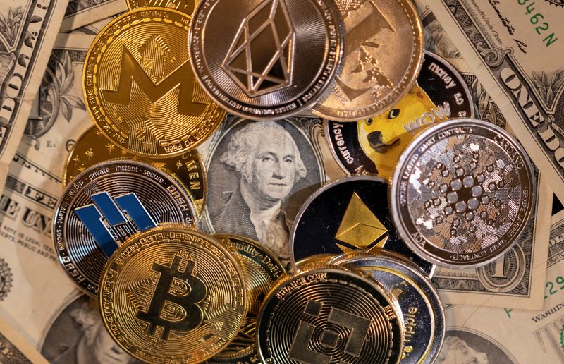 PHOTO DE FICHIER.  Image d'illustration avec des représentations de crypto-monnaies virtuelles sur des billets en dollars américains.  28 novembre 2021. REUTERS/Dado Ruvic