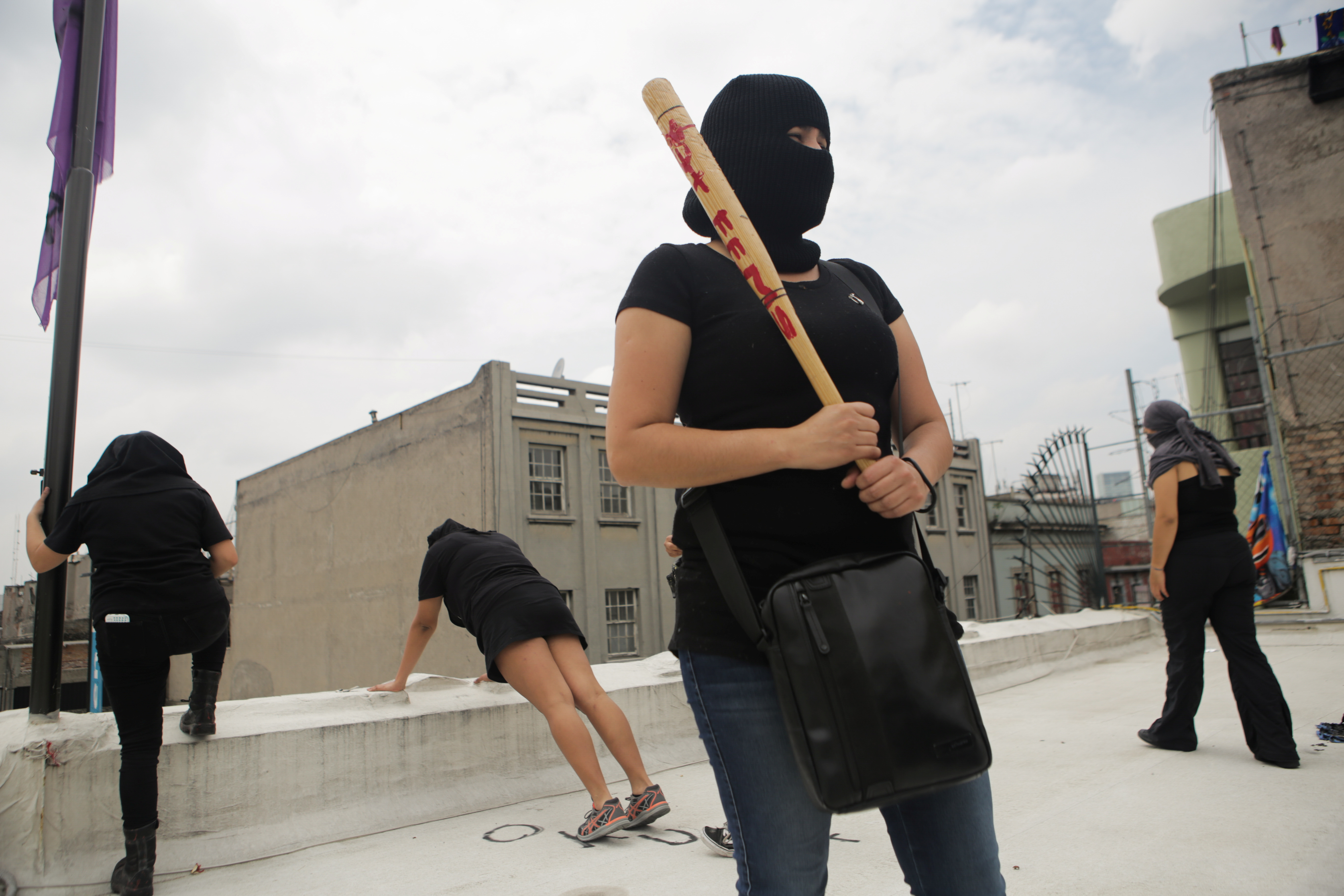 Integrante de un colectivo feminista mira por encima del techo tras ocupar las instalaciones del edificio de la Comisión Nacional de Derechos Humanos, en apoyo a víctimas de violencia de género, México 10 de septiembre de 2020. Foto tomada el 10 de septiembre de 2020.