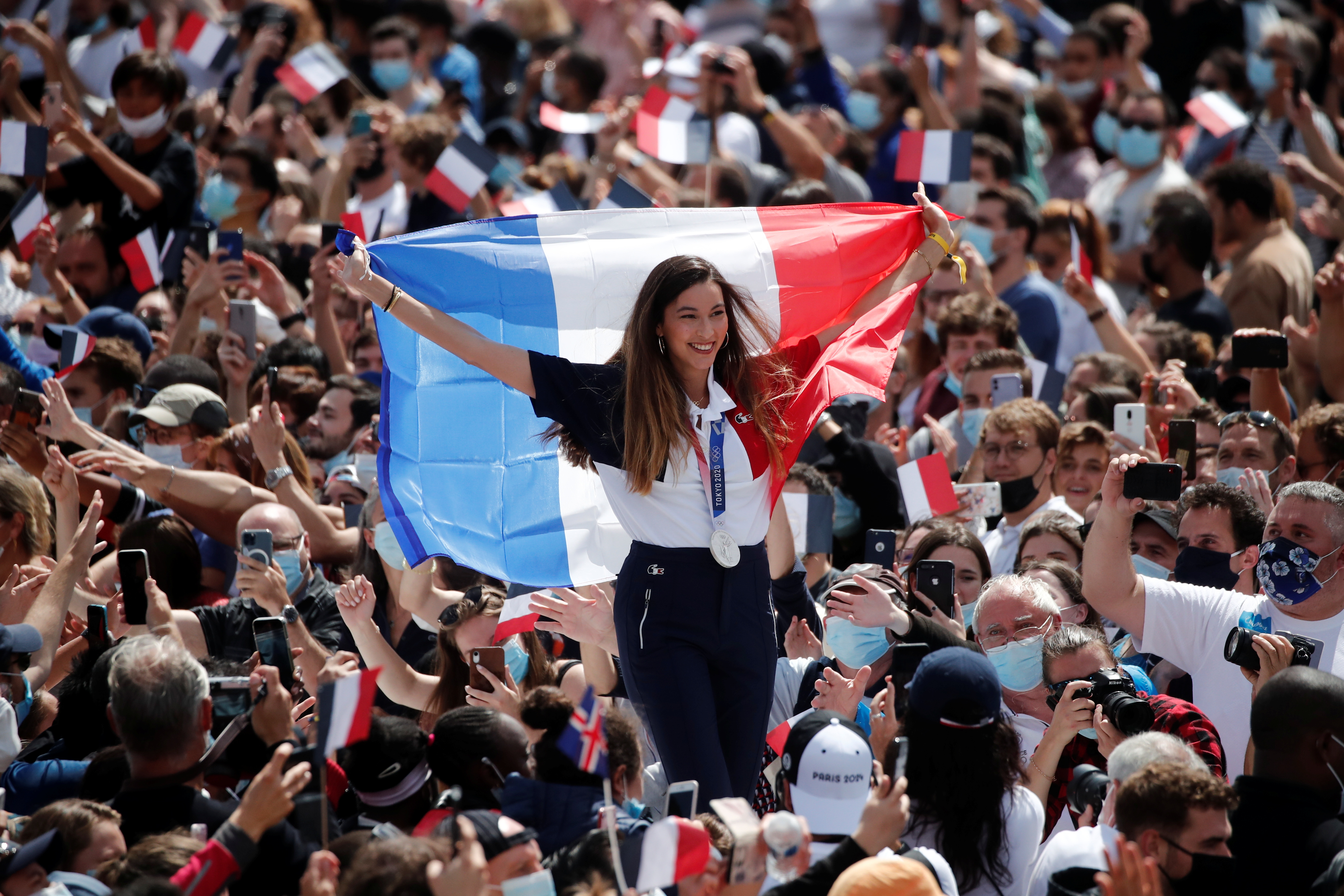 Silver medalist Charlotte Lembach of France holds a French flag as she arrives at Paris' Olympics fan zone to watch the closing ceremony of the Tokyo 2020 games at Trocadero Gardens in Paris, France, August 8, 2021. REUTERS/Benoit Tessier