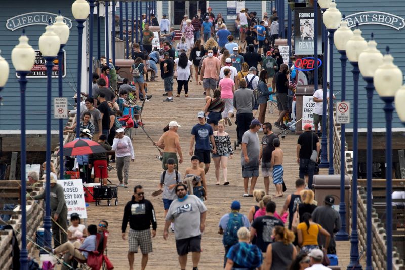  Pocas personas usan mascarillas mientras caminan por el muelle de la playa durante el brote de coronavirus en Oceanside, California, EEUU. 22 de junio de 2020. REUTERS/Mike Blake