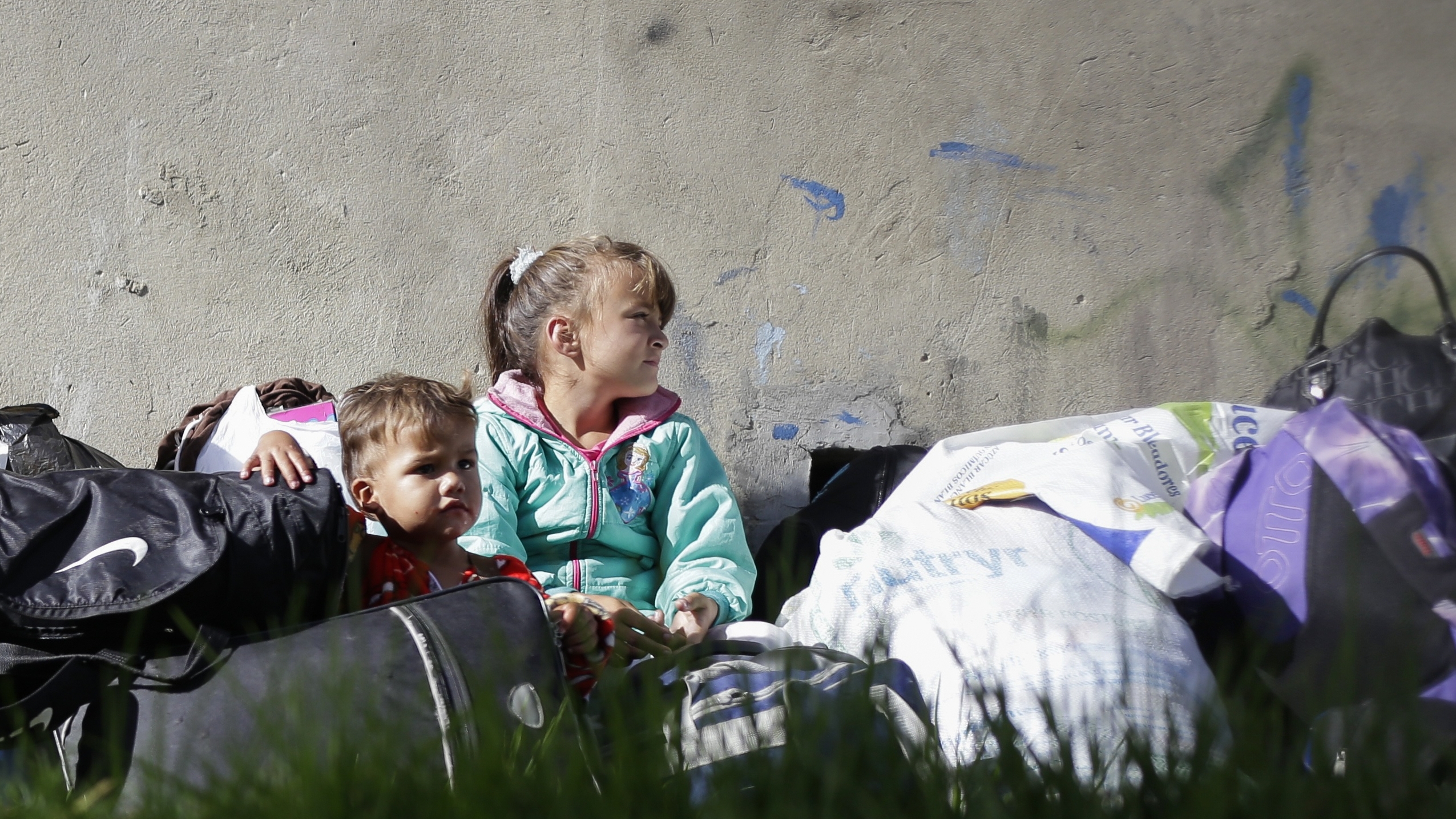 Dos niños venezolanos esperan sobre unas maletas en uno de los campamentos dispuestos para refugiados venezolanos en Bogotá (Colprensa - Sergio Acero)