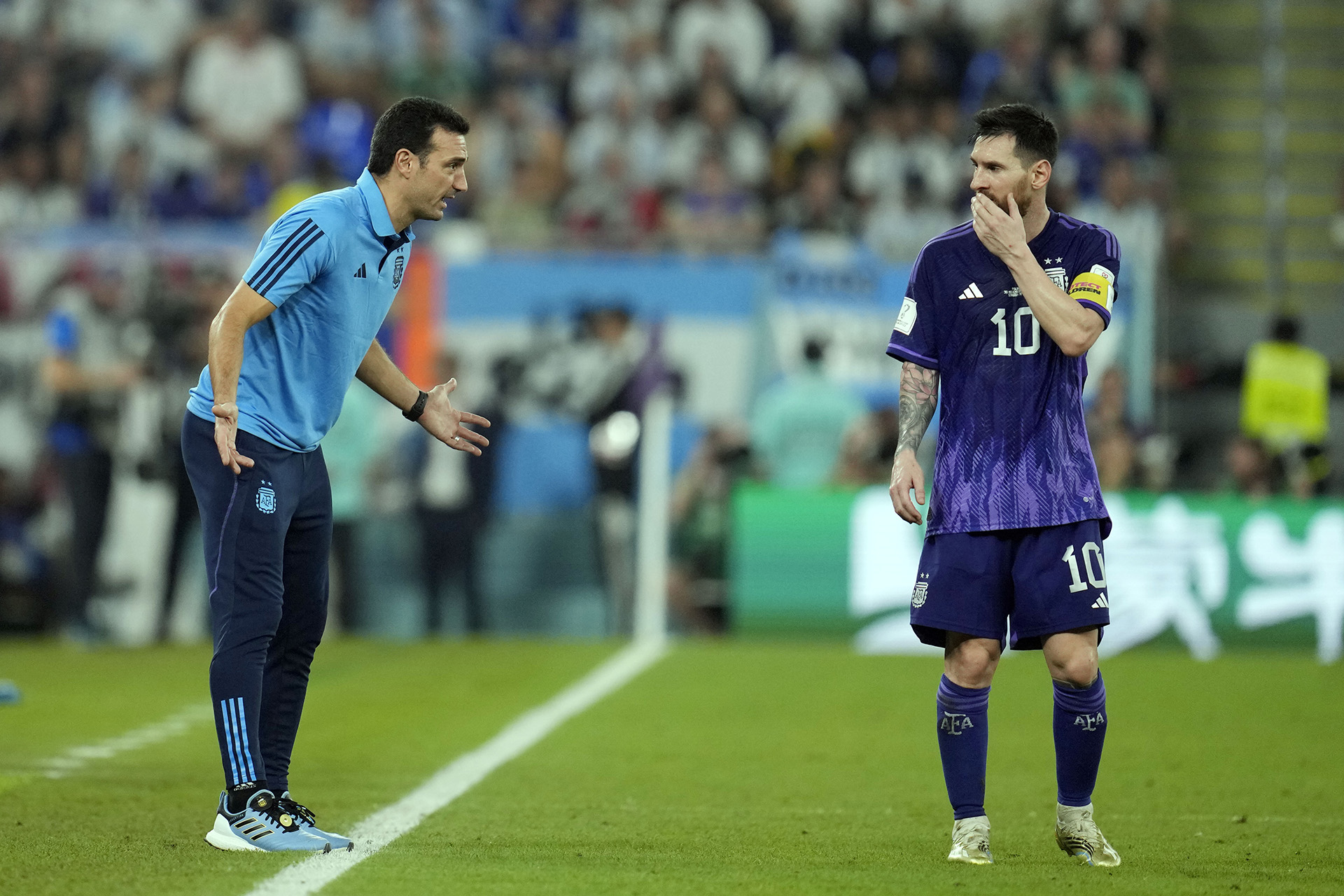 Argentina's head coach Lionel Scaloni, left, speaks with Lionel Messi during the World Cup group C soccer match between Poland and Argentina at the Stadium 974 in Doha, Qatar, Wednesday, Nov. 30, 2022. (AP Photo/Natacha Pisarenko)