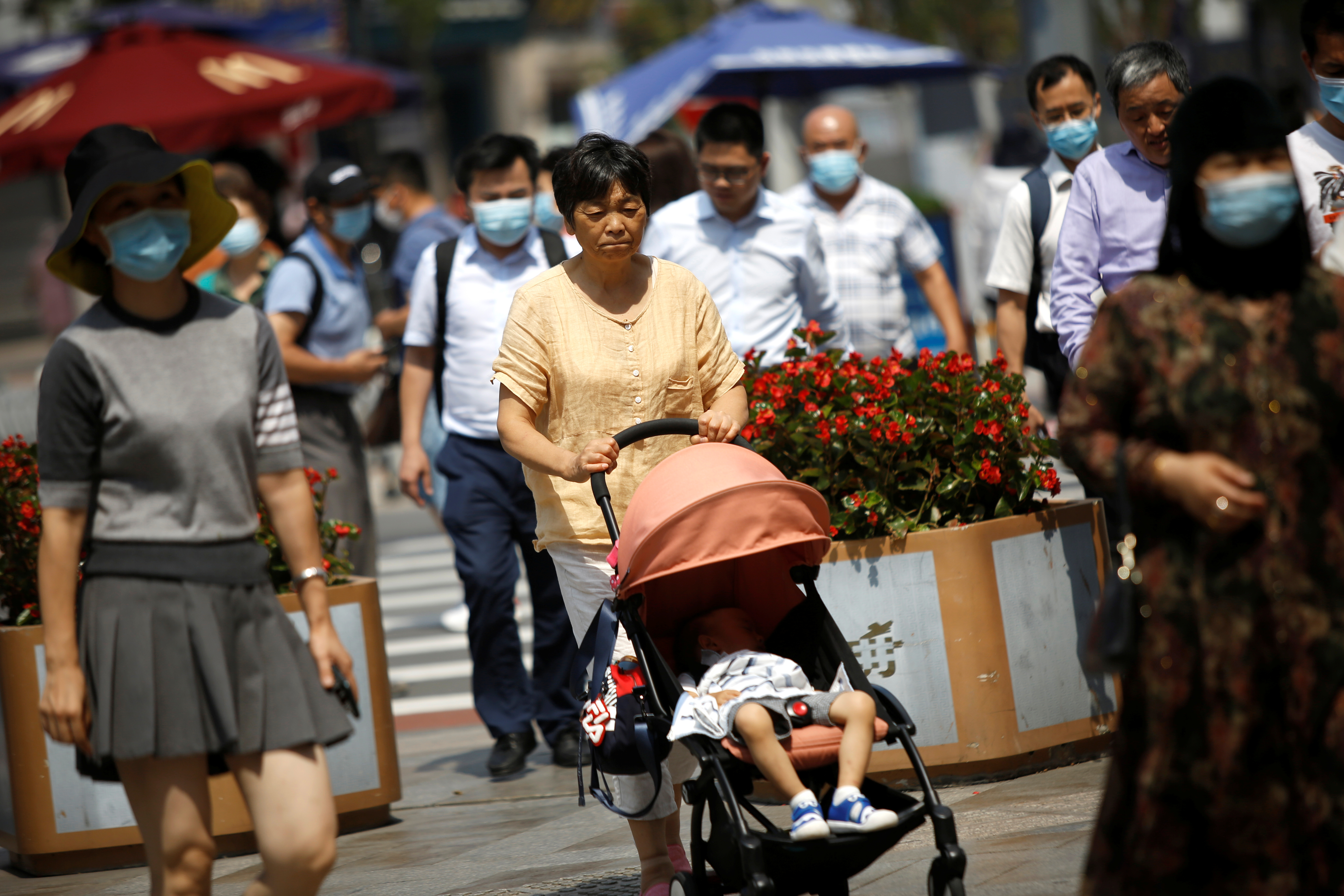 Una mujer empuja un cochecito de bebé en Beijing el 21 de agosto de 2020 (REUTERS/Tingshu Wang)