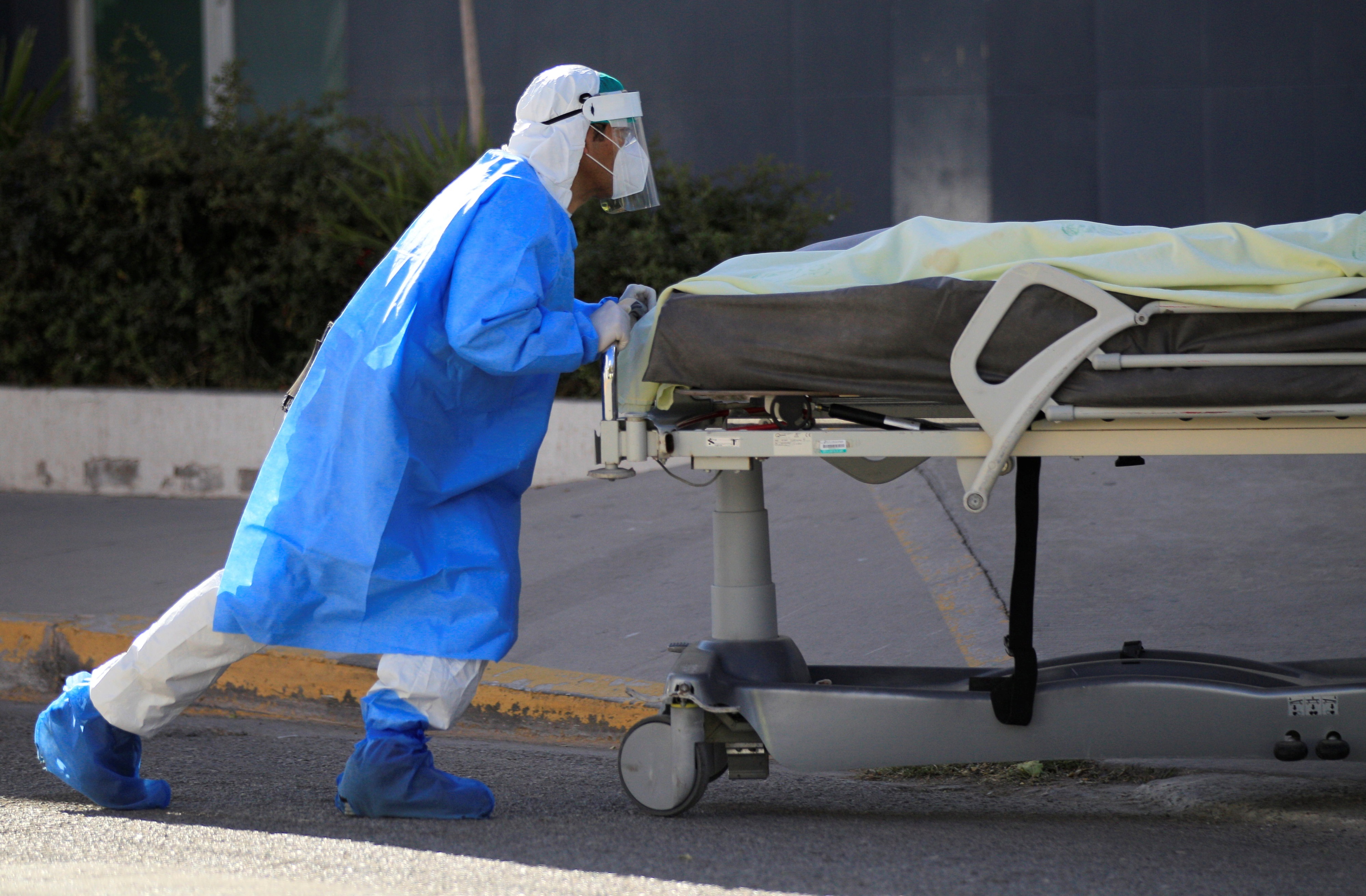 Un empleado de la salud conduce este lunes, al Servicio Médico Forense, el cuerpo de una persona fallecida por COVID-19 en el Hospital General de la fronteriza de Ciudad Juárez, en el estado de Chihuahua  (Foto: EFE/Luis Torres)