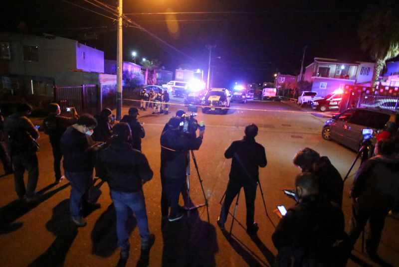 Miembros de los medios de comunicación trabajan cerca de la escena del crimen donde una periodista mexicana Lourdes Maldonado fue asesinada a tiros fuera de su casa en la ciudad fronteriza del norte de Tijuana, México, 23 de enero de 2022.  REUTERS/Jorge Duenes