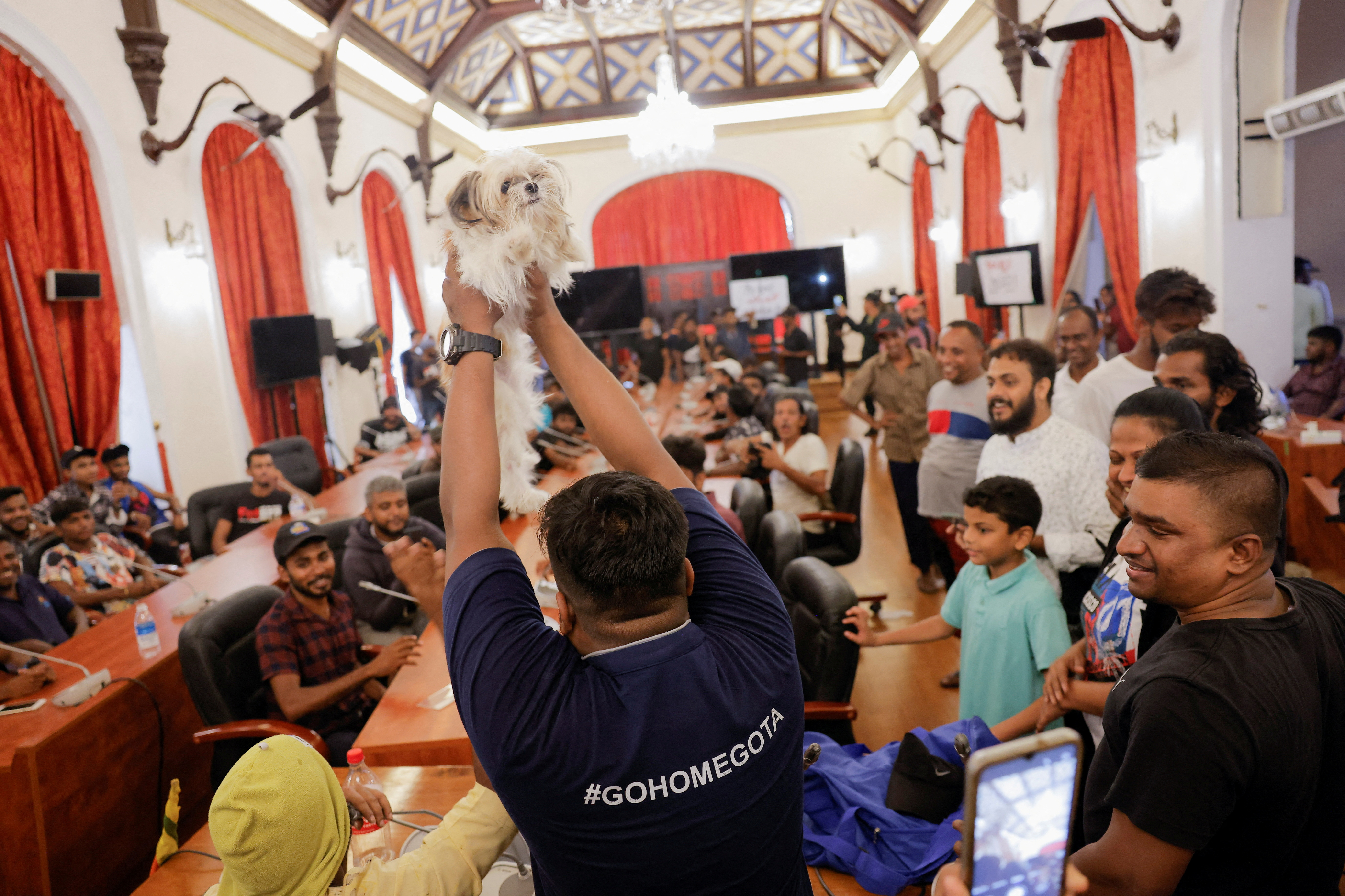 Un manifestante muestra a un perro como el nuevo "Ministro de Vida Silvestre" en la sala de reuniones del gabinete del presidente Gotabaya Rajapaksa (REUTERS/Dinuka Liyanawatte)