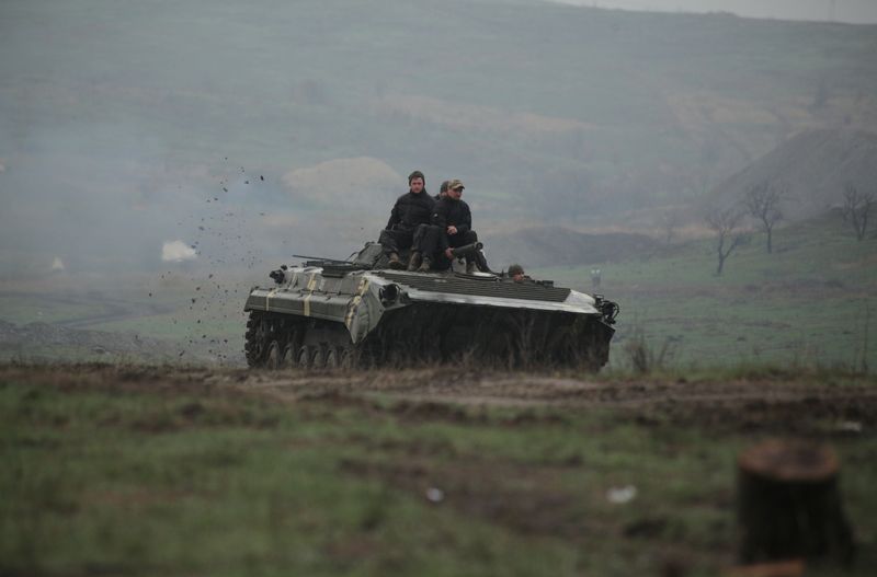 Los miembros del servicio de las fuerzas armadas de Ucrania conducen un vehículo blindado durante un entrenamiento en un campo de tiro en la región de Donetsk, Ucrania, 20 abril 2021 (REUTERS/Serhiy Takhmazov)