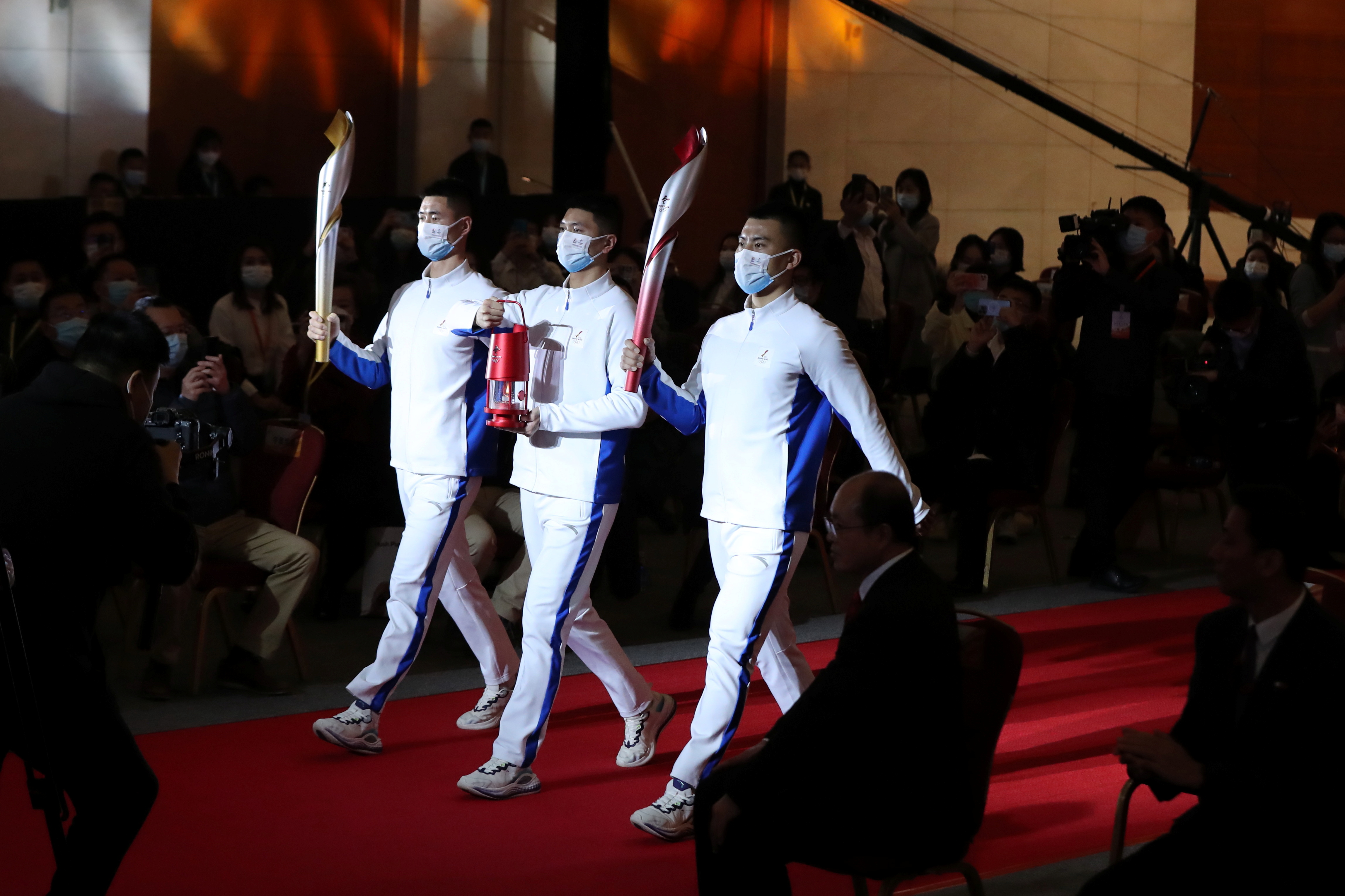 Staff members hold a safety lantern for the Olympic flame and torches of the Beijing 2022 Winter Olympics during a ceremony for a flame exhibition tour at the Sinopec building in Beijing, China December 7, 2021. China Daily via REUTERS ATTENTION EDITORS - THIS IMAGE WAS PROVIDED BY A THIRD PARTY. CHINA OUT.