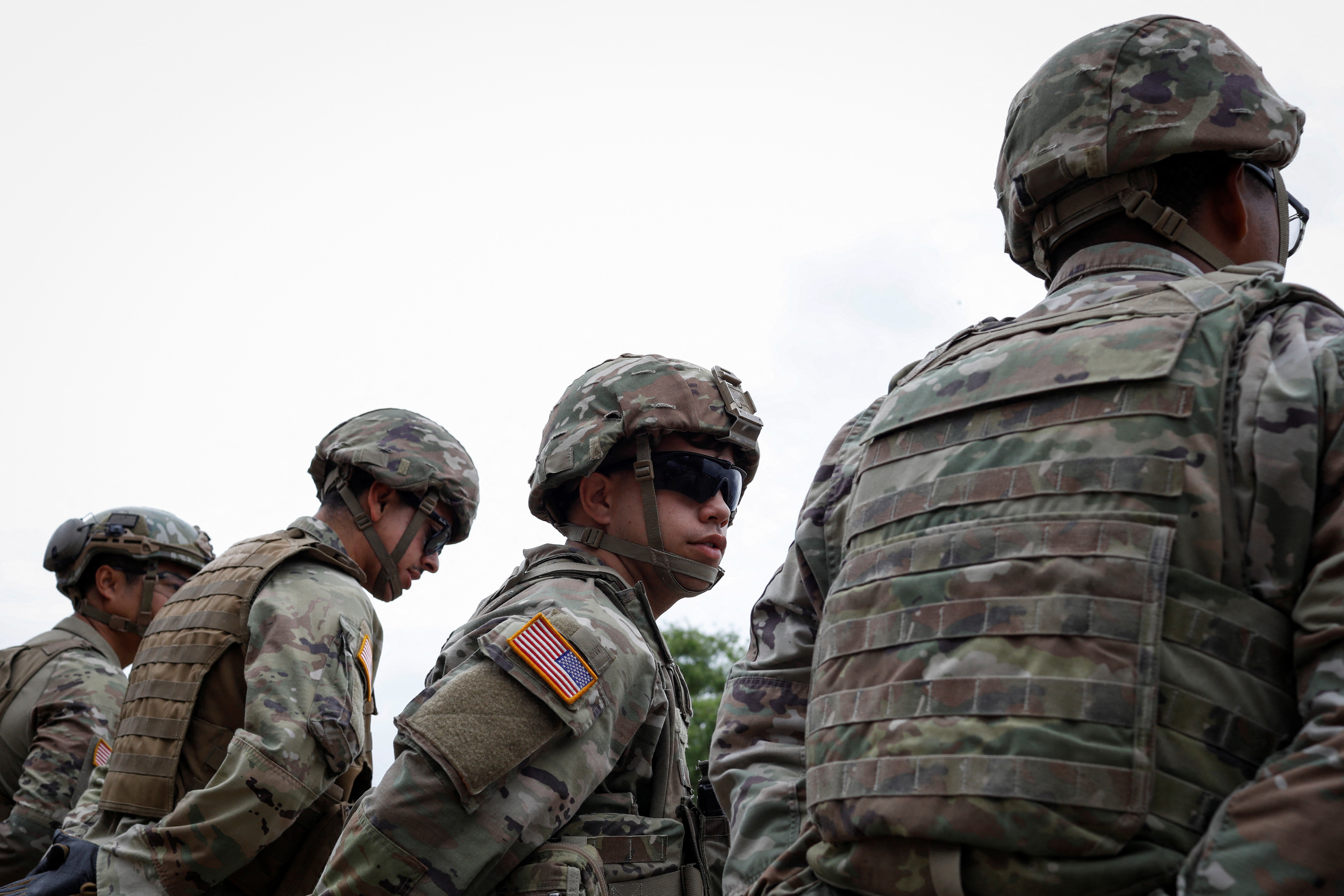 Texas Army National Guard members stand guard during a visit of Texas Governor Greg Abbott to the north banks of the Rio Grande in Eagle Pass, Texas, U.S. May 23, 2022. U.S. authorities, blocked by a federal judge from lifting COVID-19 restrictions that empower agents at the U.S.-Mexico border to turn back migrants, continue to enforce the Title 42 rules which result in the fast expulsion of migrants to Mexico or other countries. REUTERS/Marco Bello
