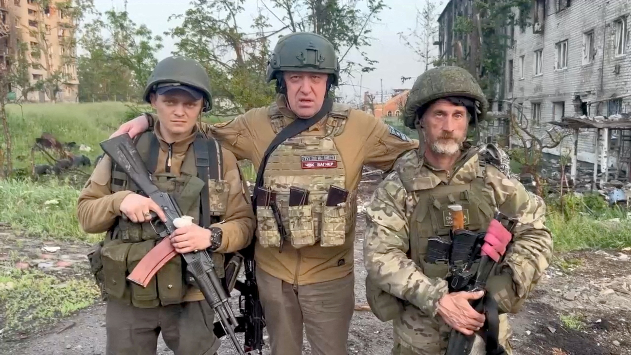 The founder of the private mercenary group Wagner, Yevgeny Prigozhin, poses with the mercenaries "Pepper" y "Dolik" during a statement about the start of the withdrawal of his forces from Bakhmut and the handing over of their positions to Russian regular troops, in the course of the conflict between Russia and Ukraine in Bakhmut, Ukraine, in this still image taken from a video released on May 25, 2023 (Reuters)