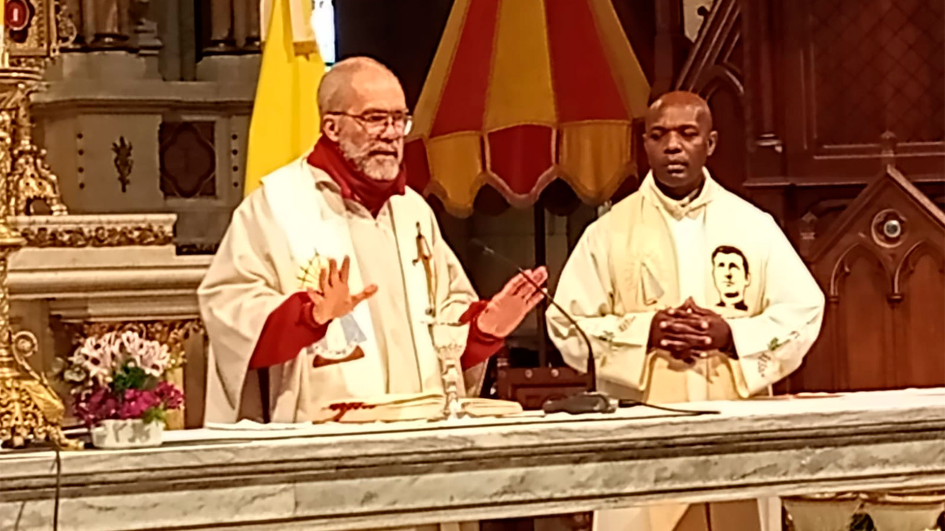 Celebran la misa los sacerdotes Sergio G&oacute;mez Tey y Juan Bosco, ruand&eacute;s, misionando en Villa Celina, barrio 17 de noviembre