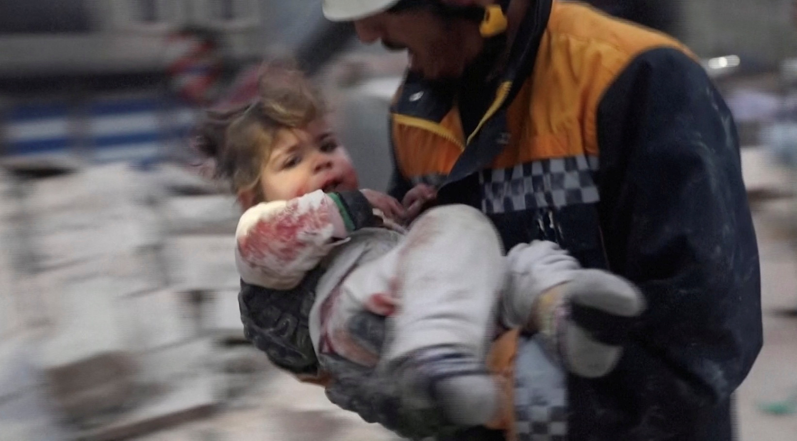Un rescatista lleva a un niño herido lejos de los escombros de un edificio luego de un terremoto en Azaz, Siria, controlada por los rebeldes.

