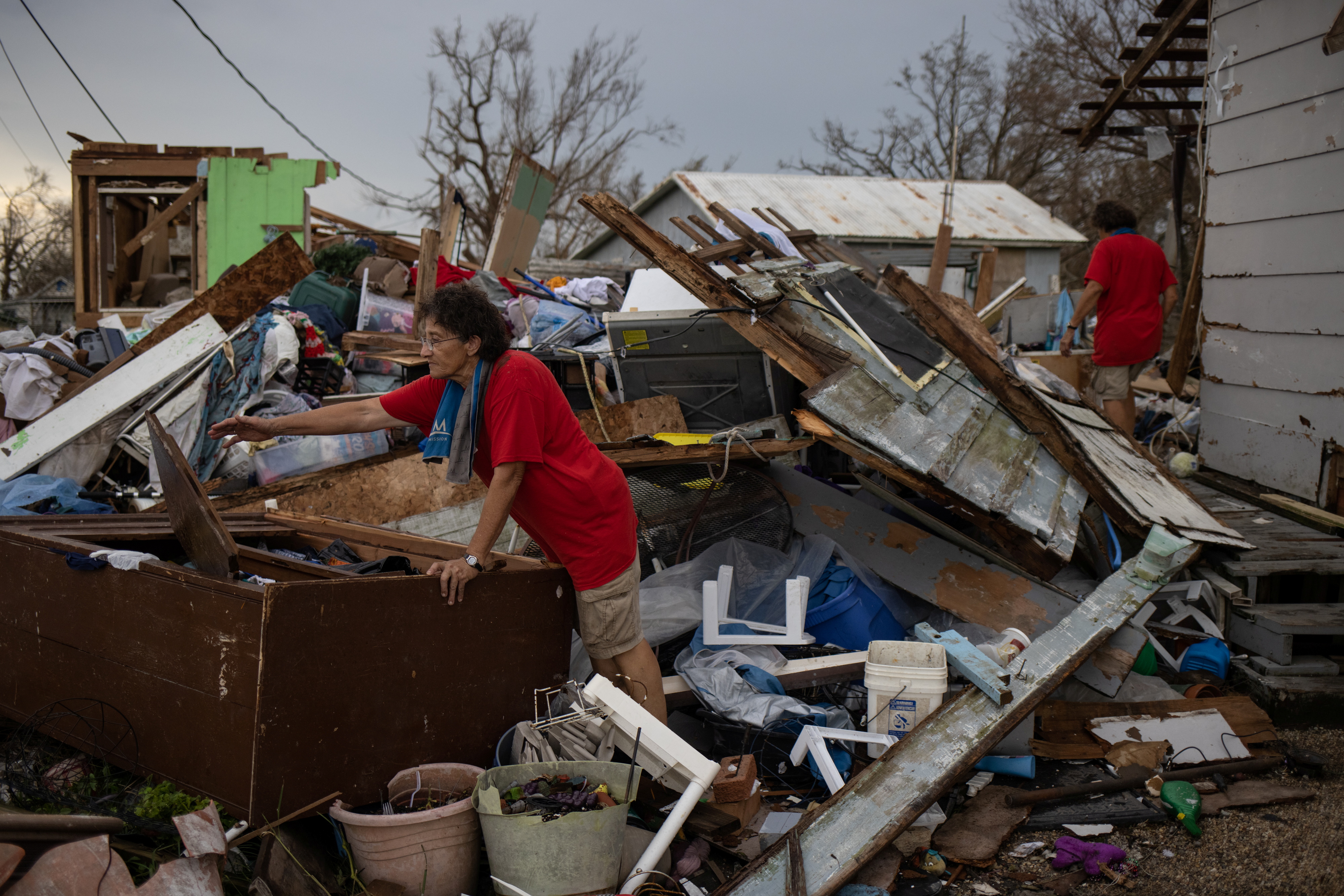 Unas hermanas tratan de rescatar artículos personas bajo los escombros en los que quedó su vivienda tras el paso de Ida por Louisiana