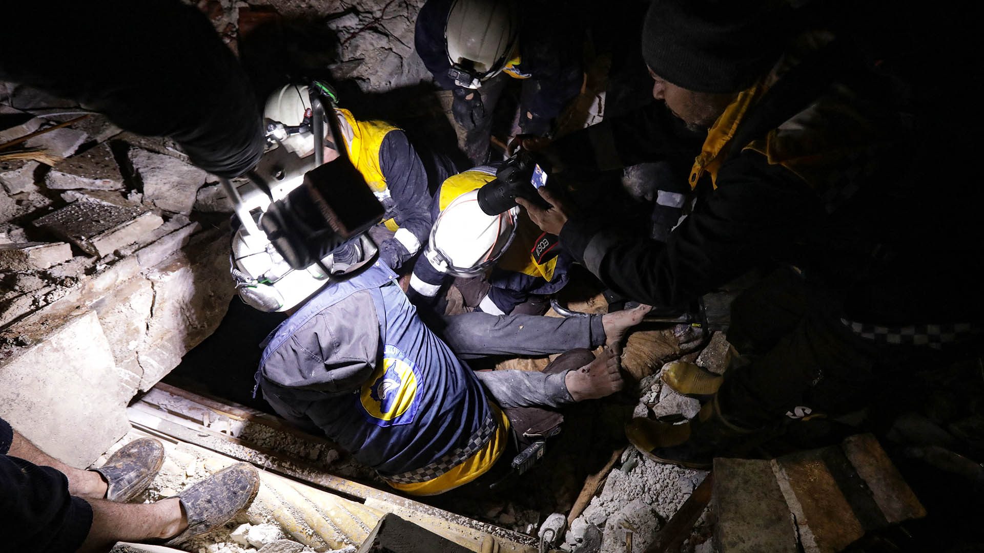 Rescatistas sirios (Cascos Blancos) recuperan a un hombre herido de los escombros de un edificio derrumbado tras un terremoto, en la ciudad fronteriza de Azaz, en el norte de la provincia de Alepo, controlada por los rebeldes.
