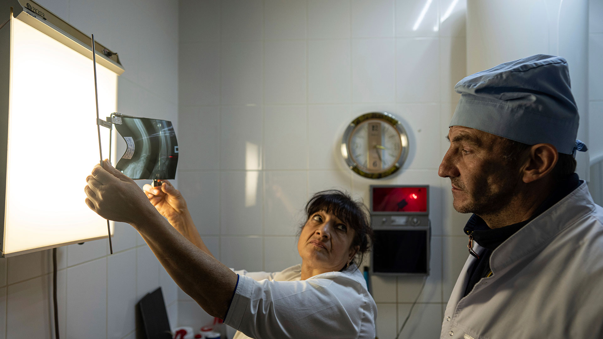 El Dr. Yurii Kuznetsov observa una radiografía en el hospital de Izium, Ucrania. El personal médico lucha contra los recuerdos de seis meses mortales bajo la ocupación rusa. (Foto AP/Evgeniy Maloletka)