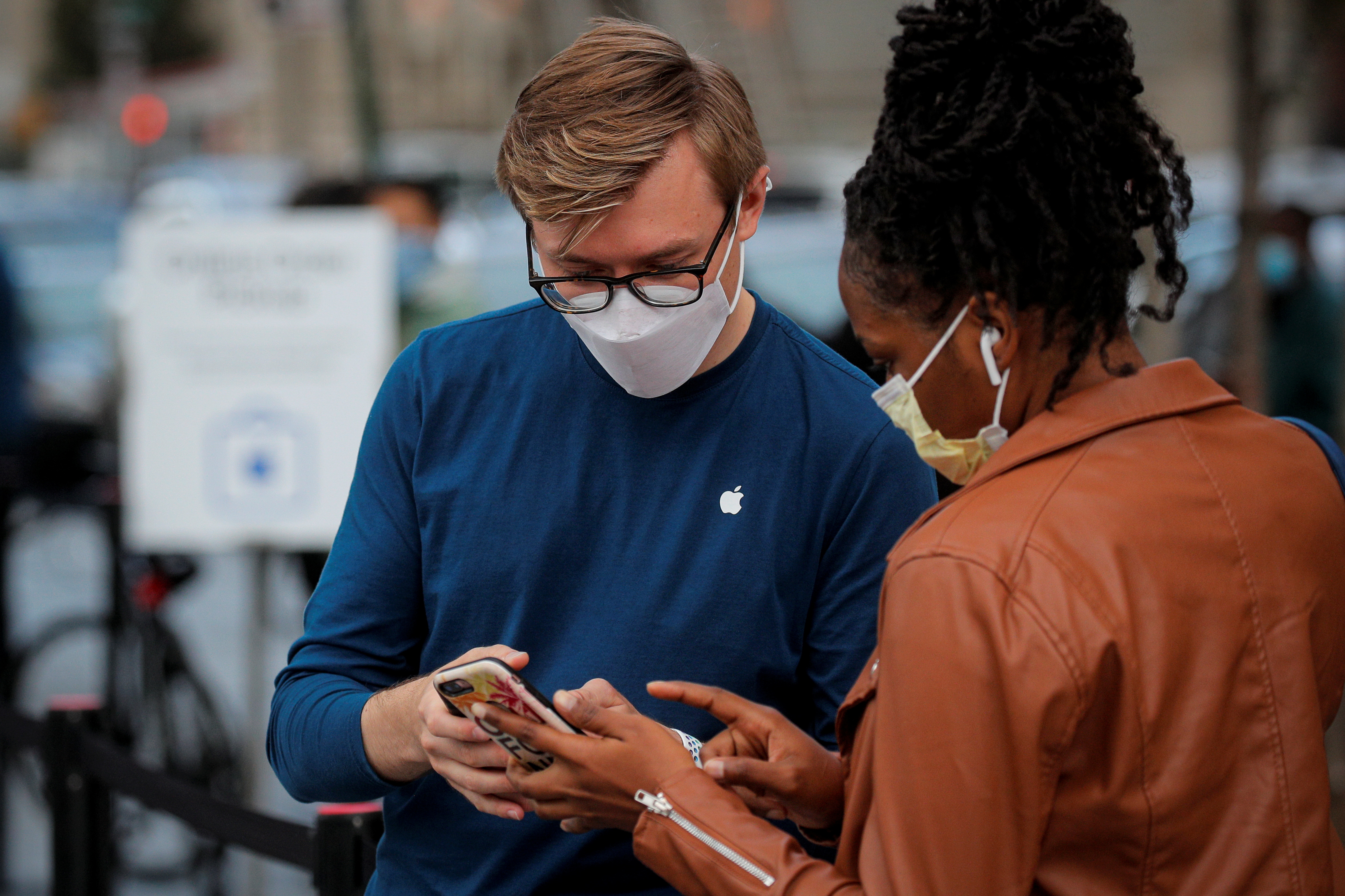 Un cliente habla con un empleado fuera de una Apple Store para recoger el nuevo iPhone 12 5G de Apple en Brooklyn, Nueva York, EE. UU., 23 de octubre de 2020. REUTERS/Brendan McDermid