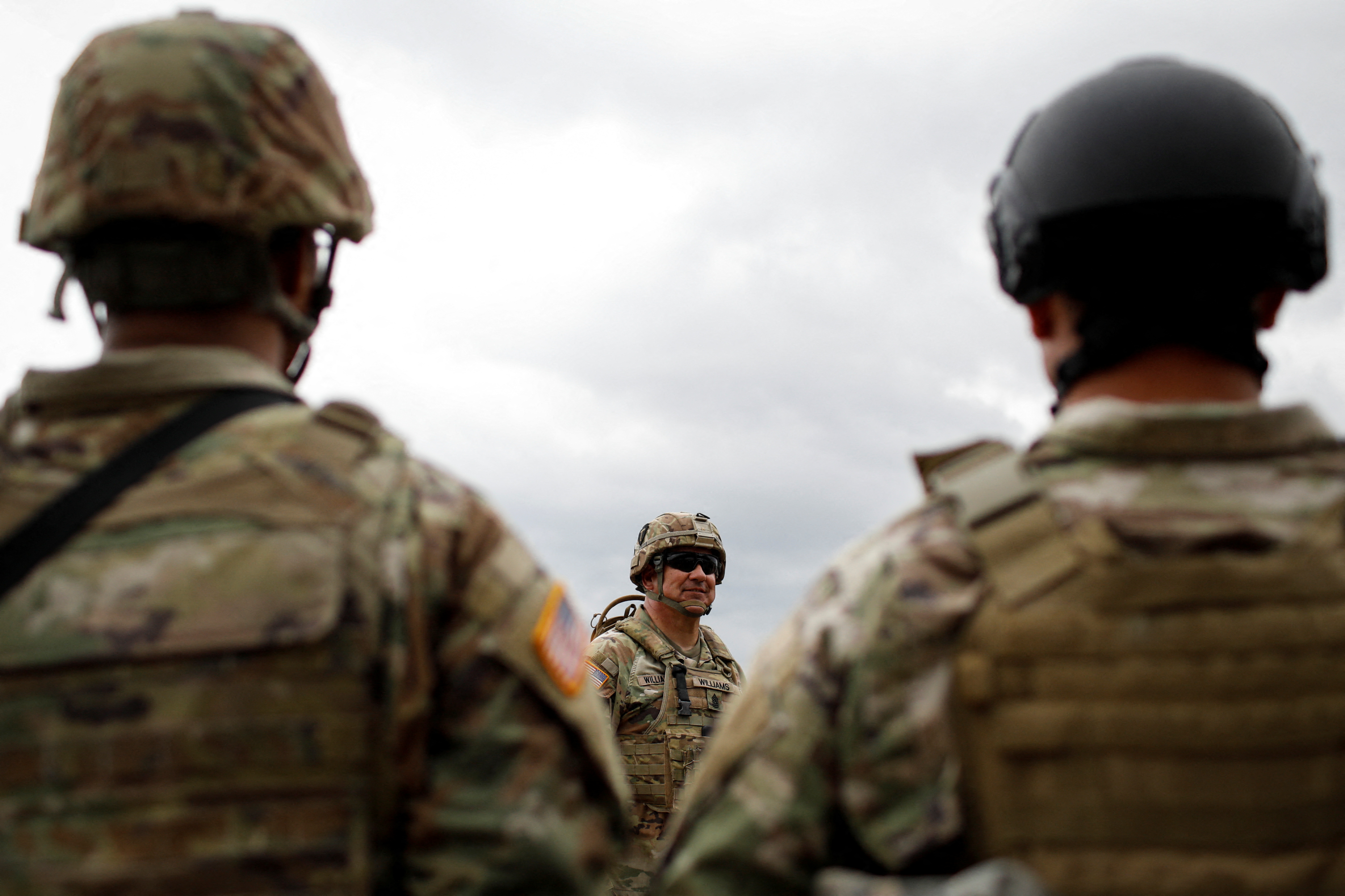 Texas Army National Guard members stand guard during a visit of Texas Governor Greg Abbott to the north banks of the Rio Grande in Eagle Pass, Texas, U.S. May 23, 2022. U.S. authorities, blocked by a federal judge from lifting COVID-19 restrictions that empower agents at the U.S.-Mexico border to turn back migrants, continue to enforce the Title 42 rules which result in the fast expulsion of migrants to Mexico or other countries. REUTERS/Marco Bello