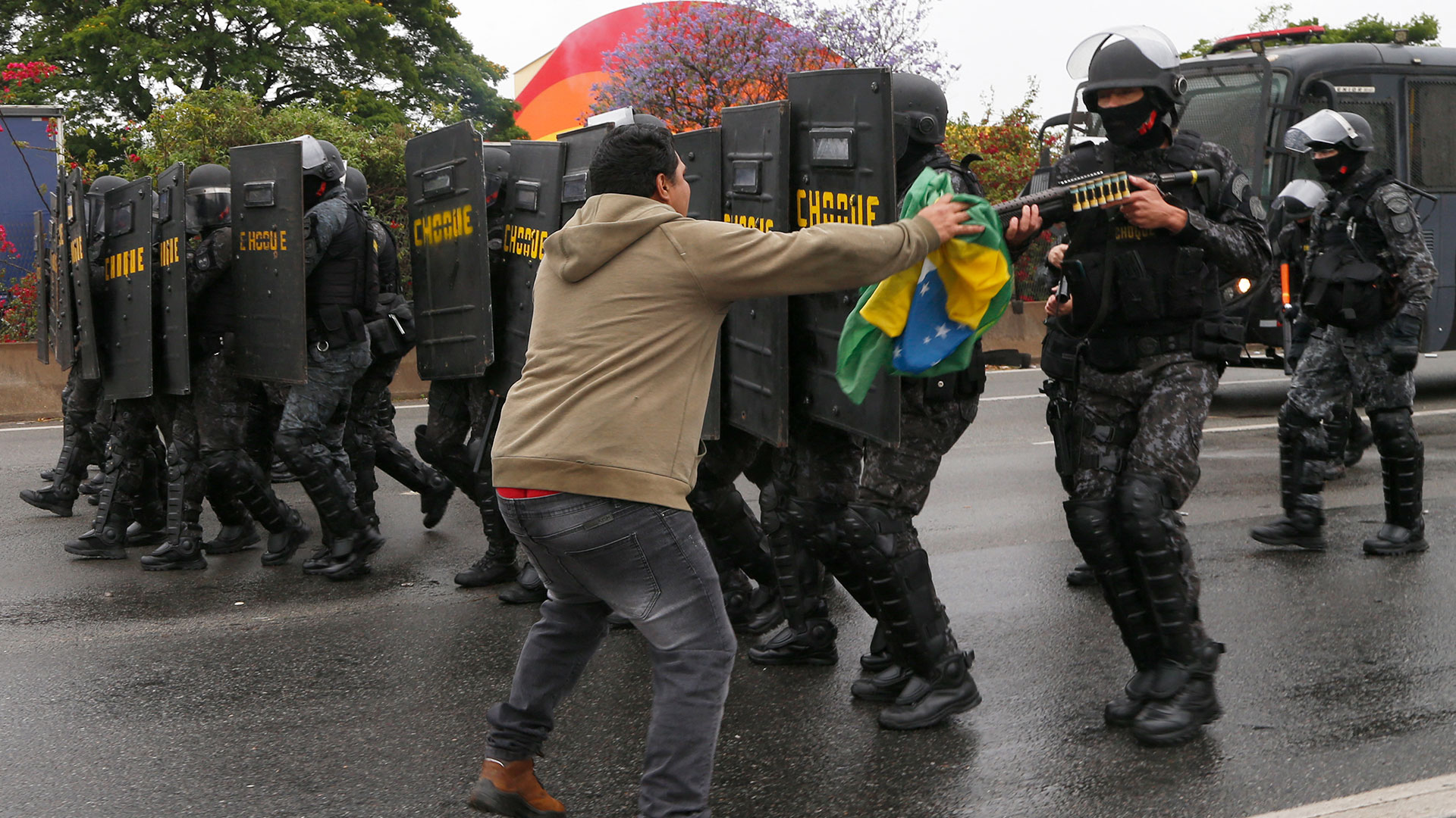 Un hombre choca con antidisturbios durante un bloqueo realizado por simpatizantes del presidente Jair Bolsonaro