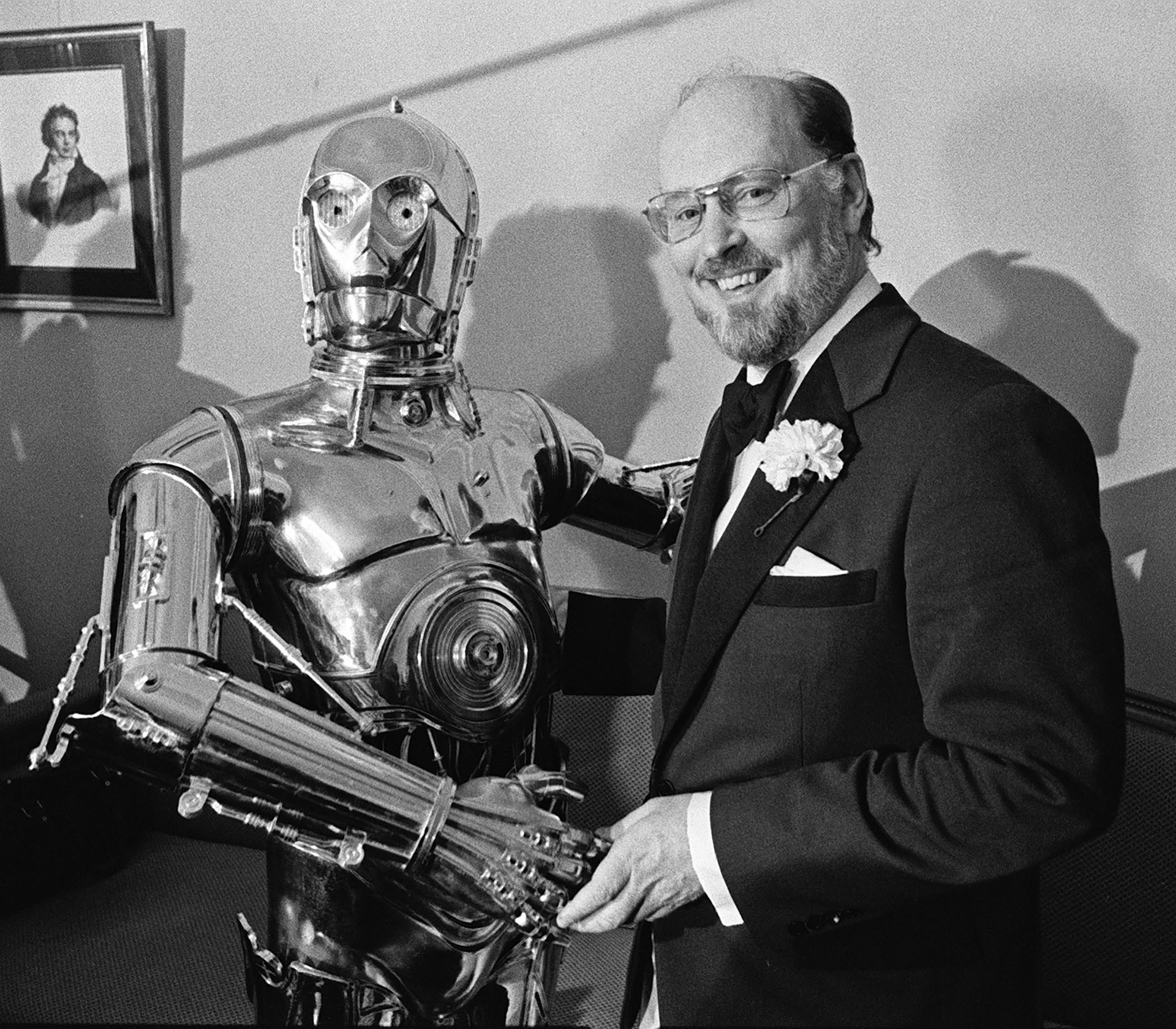 Williams, a la derecha, le da la mano al personaje C-3PO de "Star Wars" en una conferencia de prensa en Boston el 30 de abril de 1980. (Foto AP, archivo)