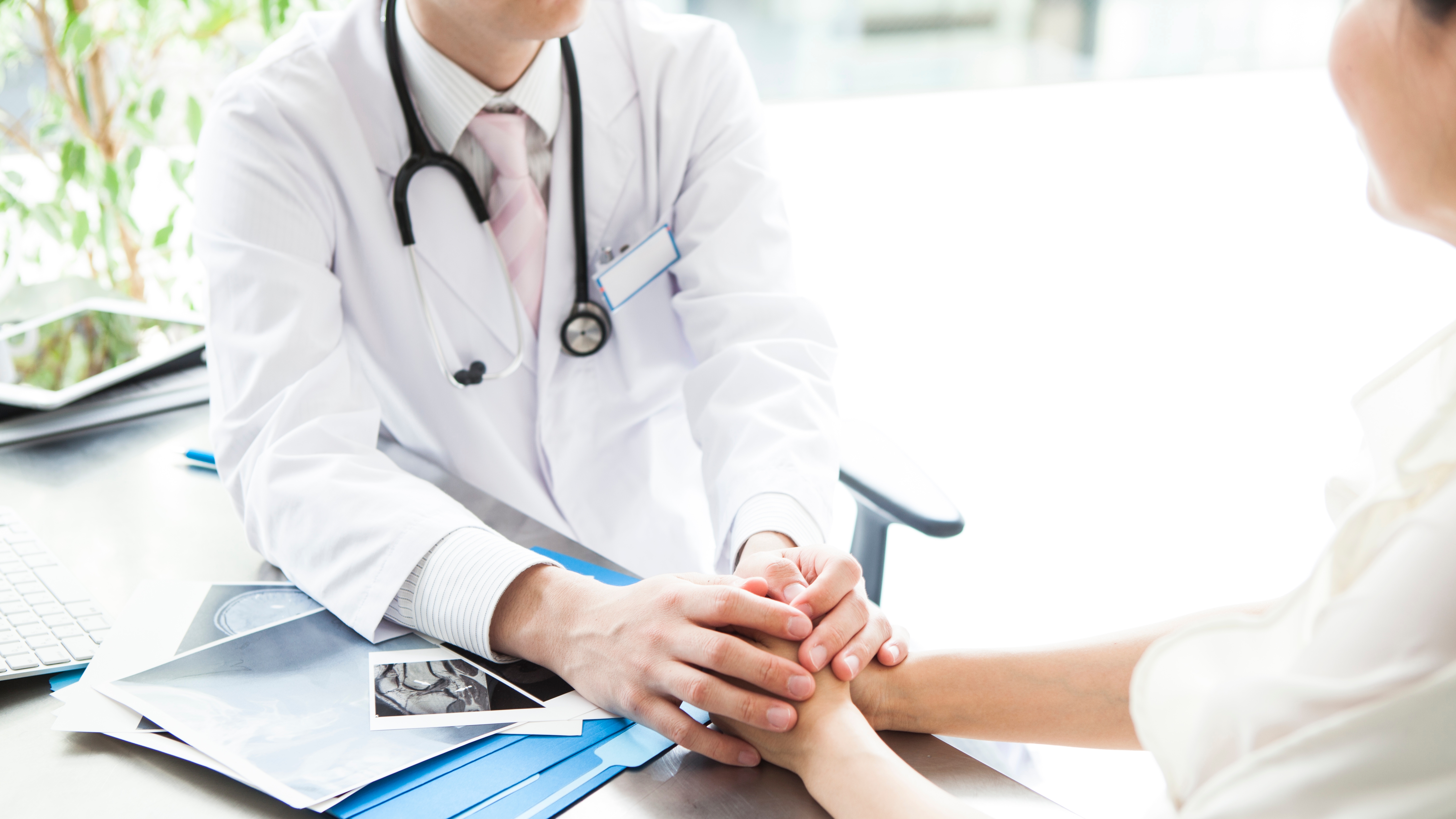 Doctor holding the hand of the patient in hospital