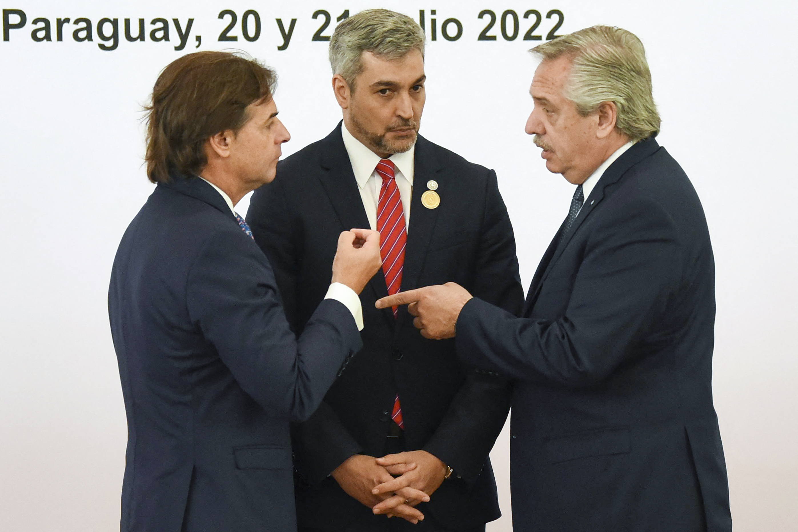 Uruguayan President Luis Lacalle Pou (L), Paraguayan President Mario Abdo Benitez (C) and Argentine President Alberto Fernandez speak after the Mercosur Summit in Luque, Paraguay, on July 21, 2022. (Photo by DANIEL DUARTE / AFP)