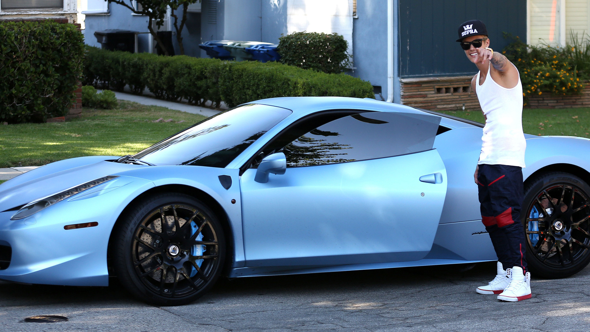 Justin Bieber mostrando su Ferrari azul brillante, con los logos laterales pintados de azul
